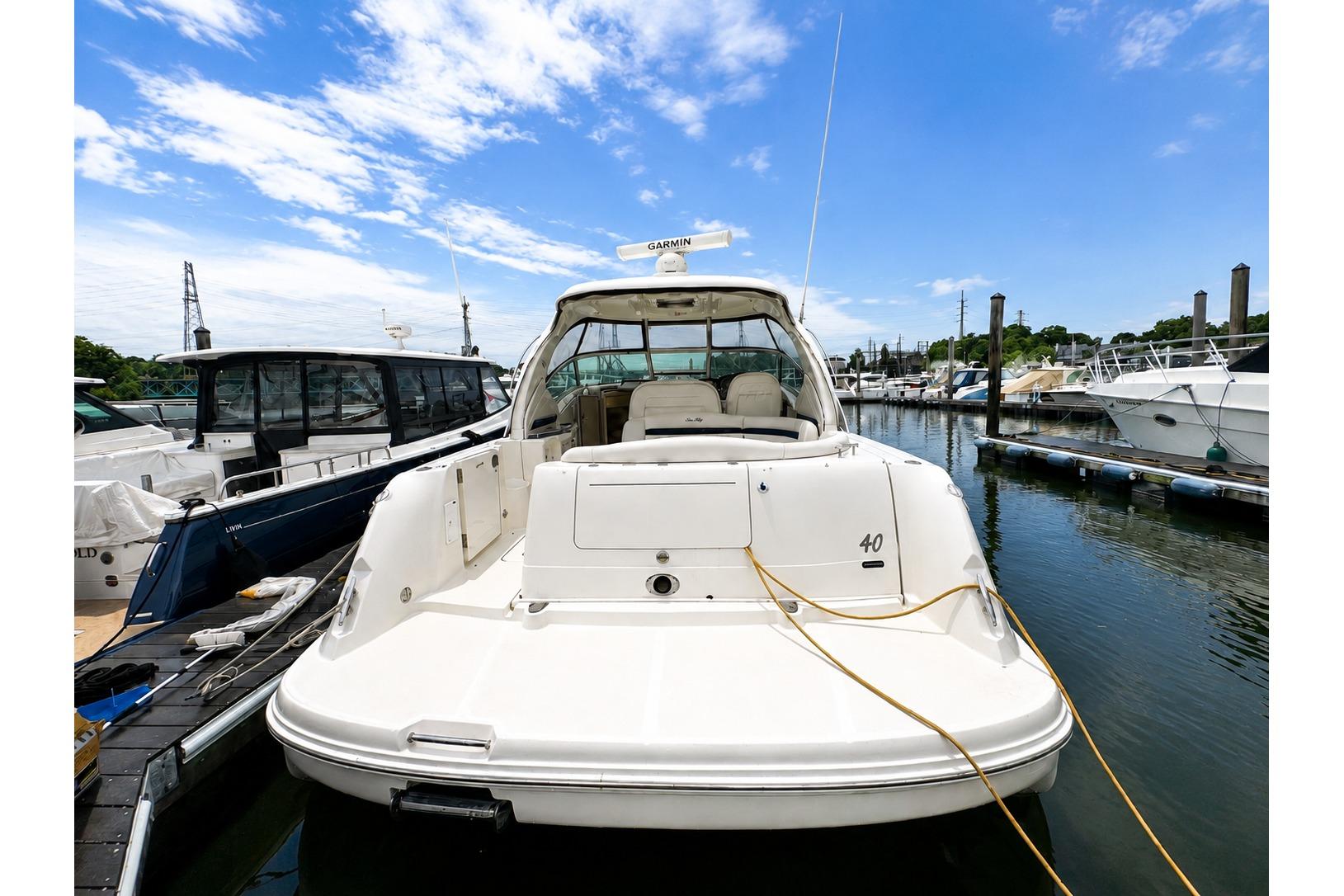 2006 Sea Ray 40 Sundancer yacht docked at marina under blue sky.