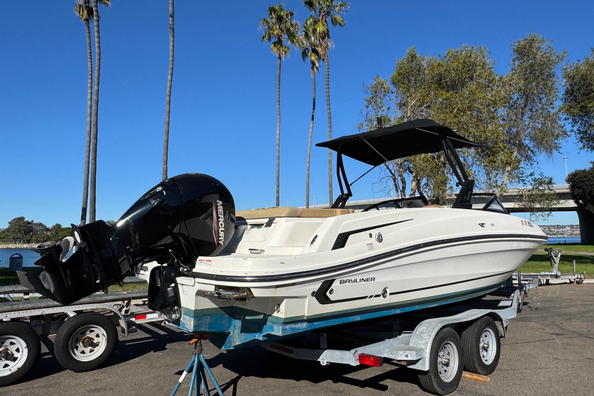 2022 Bayliner VR6 Bowrider OB on trailer, parked near palm trees and water.
