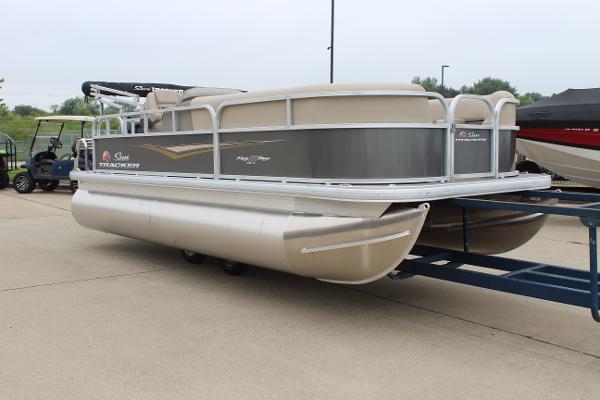 2025 Sun Tracker Party Barge 18 DLX pontoon boat on trailer, parked outdoors.