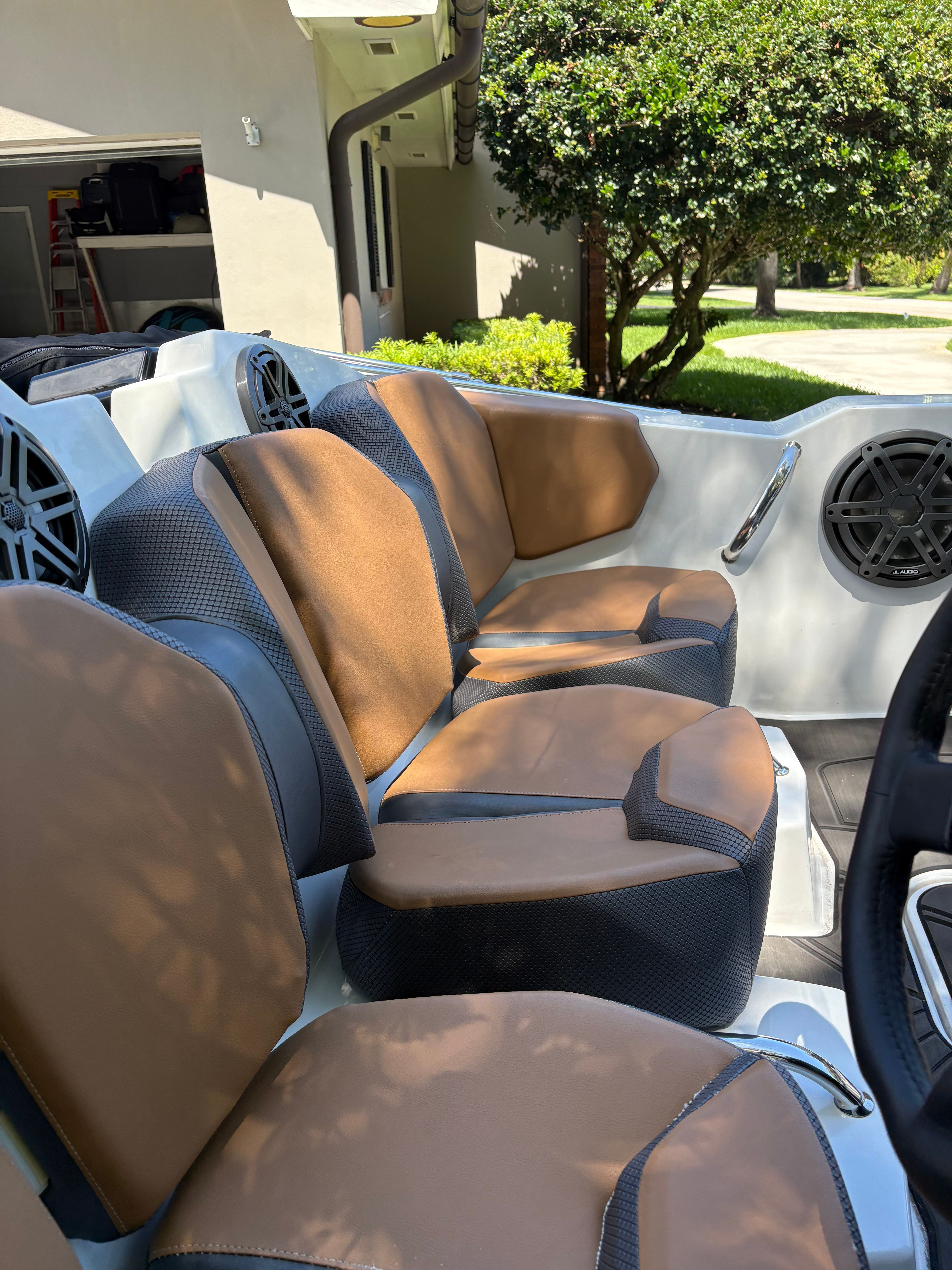 Interior view of a 2022 Scarab 165 ID boat with brown and gray seats.