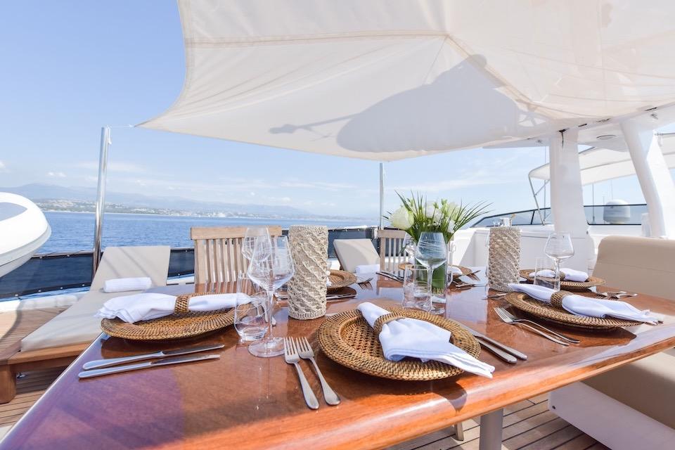 Elegant dining setup on 1984 W.A. Souter & Sons yacht, featuring ocean view and stylish tableware.