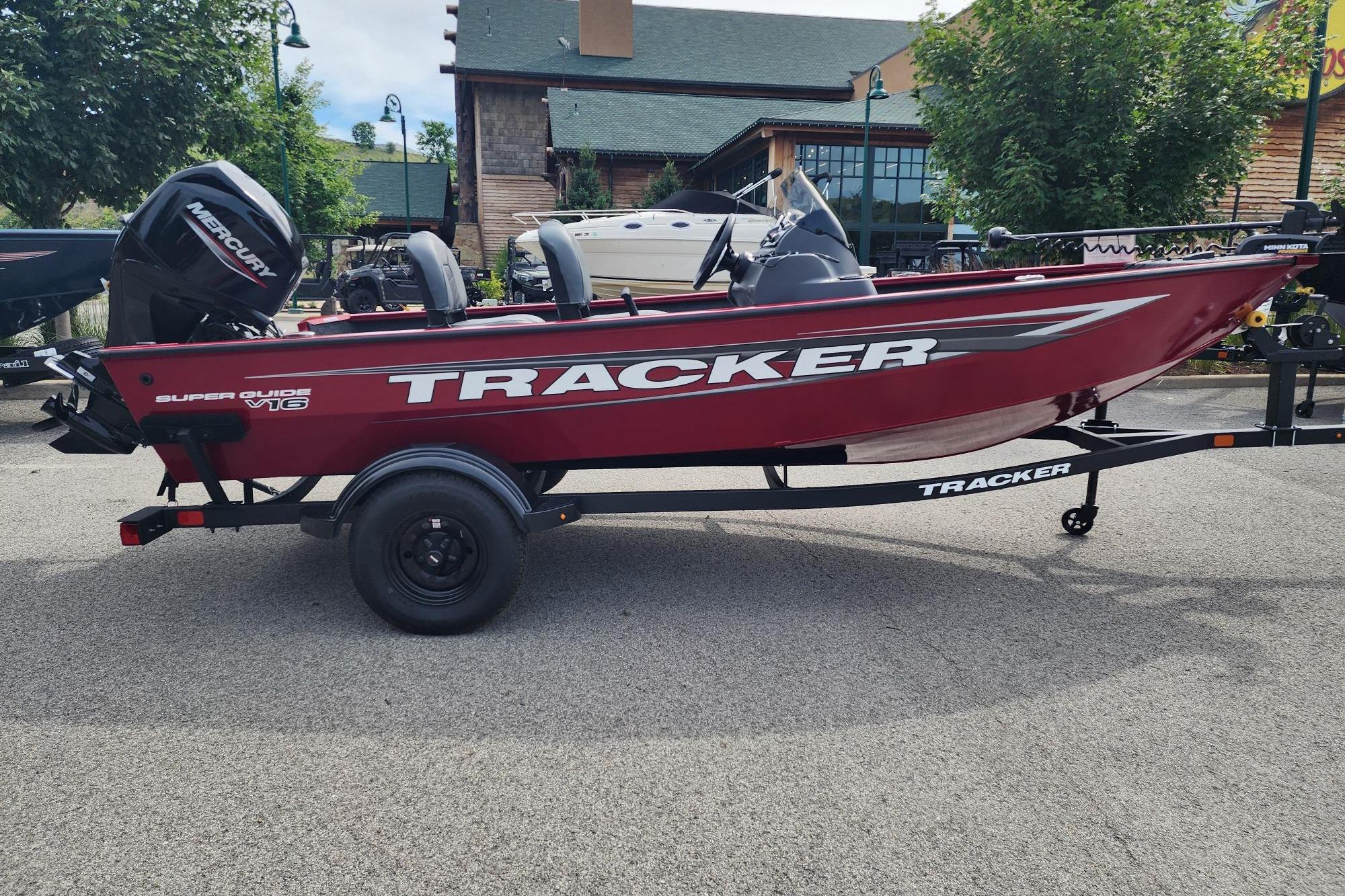 2026 Tracker Super Guide V-16 SC boat on trailer, red exterior, parked outdoors.