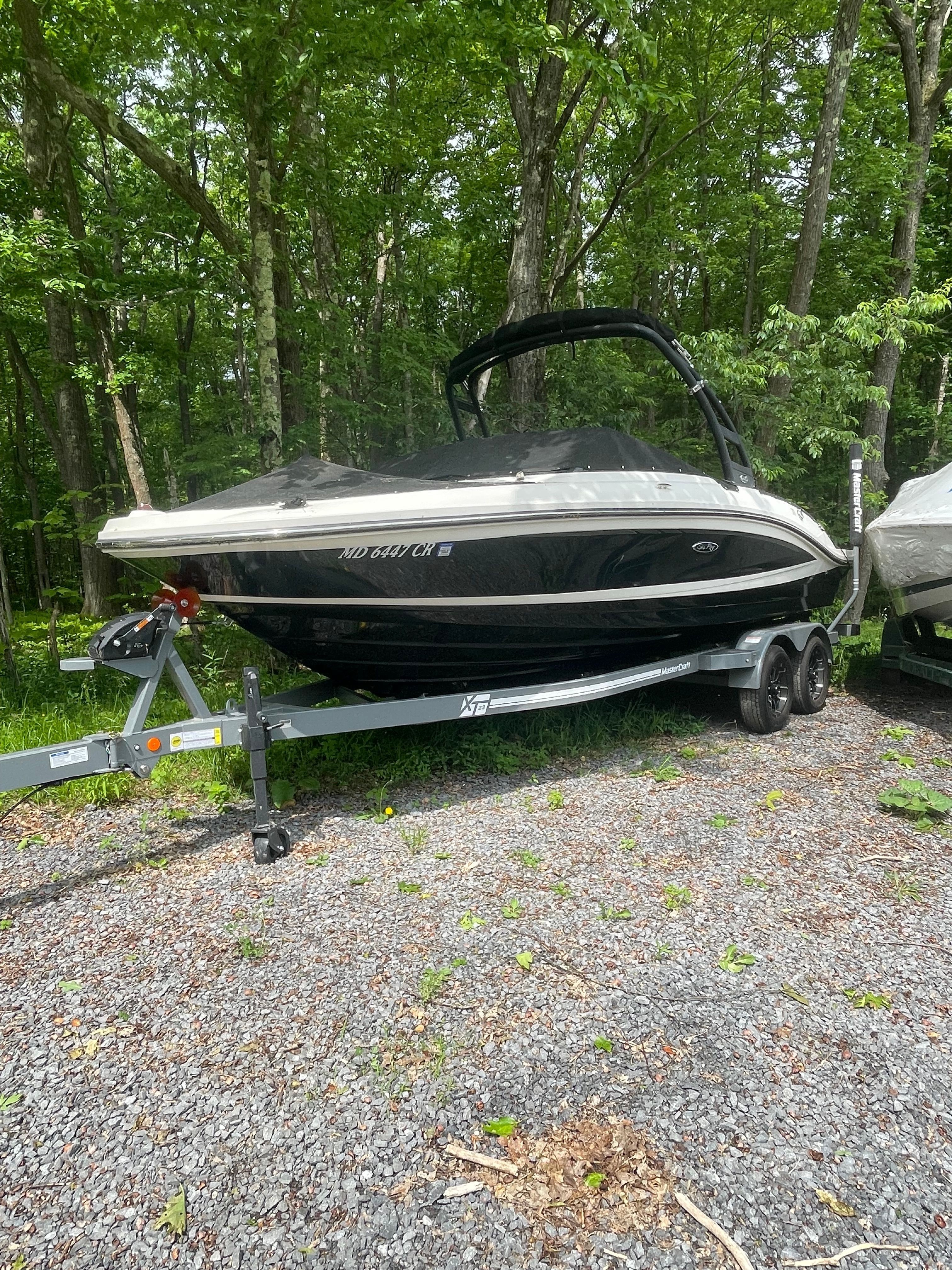 2016 Sea Ray 21 SPX boat on trailer in forest.