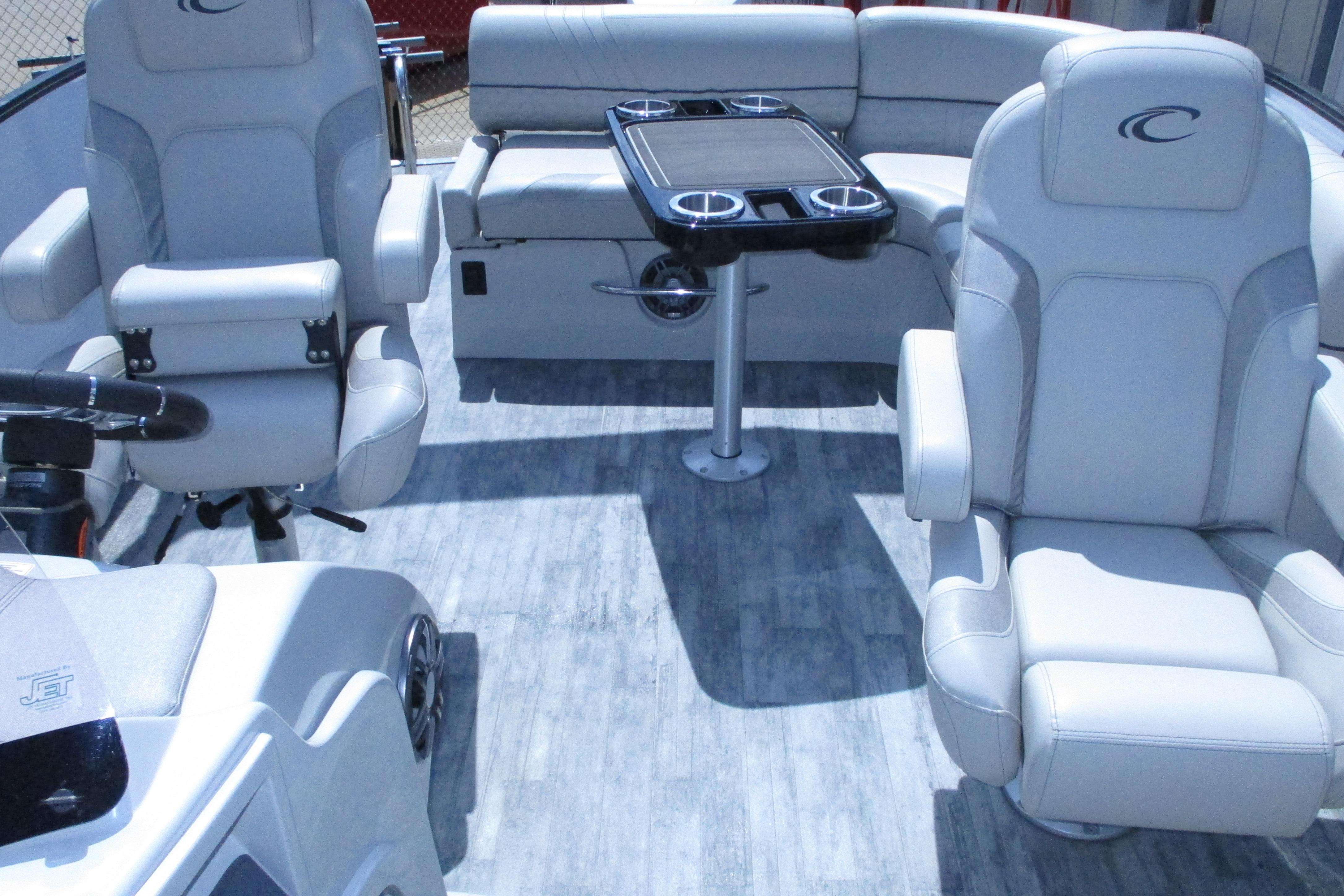 Interior of 2021 Crest Caribbean LX 250 SLS pontoon boat with plush seating and table.