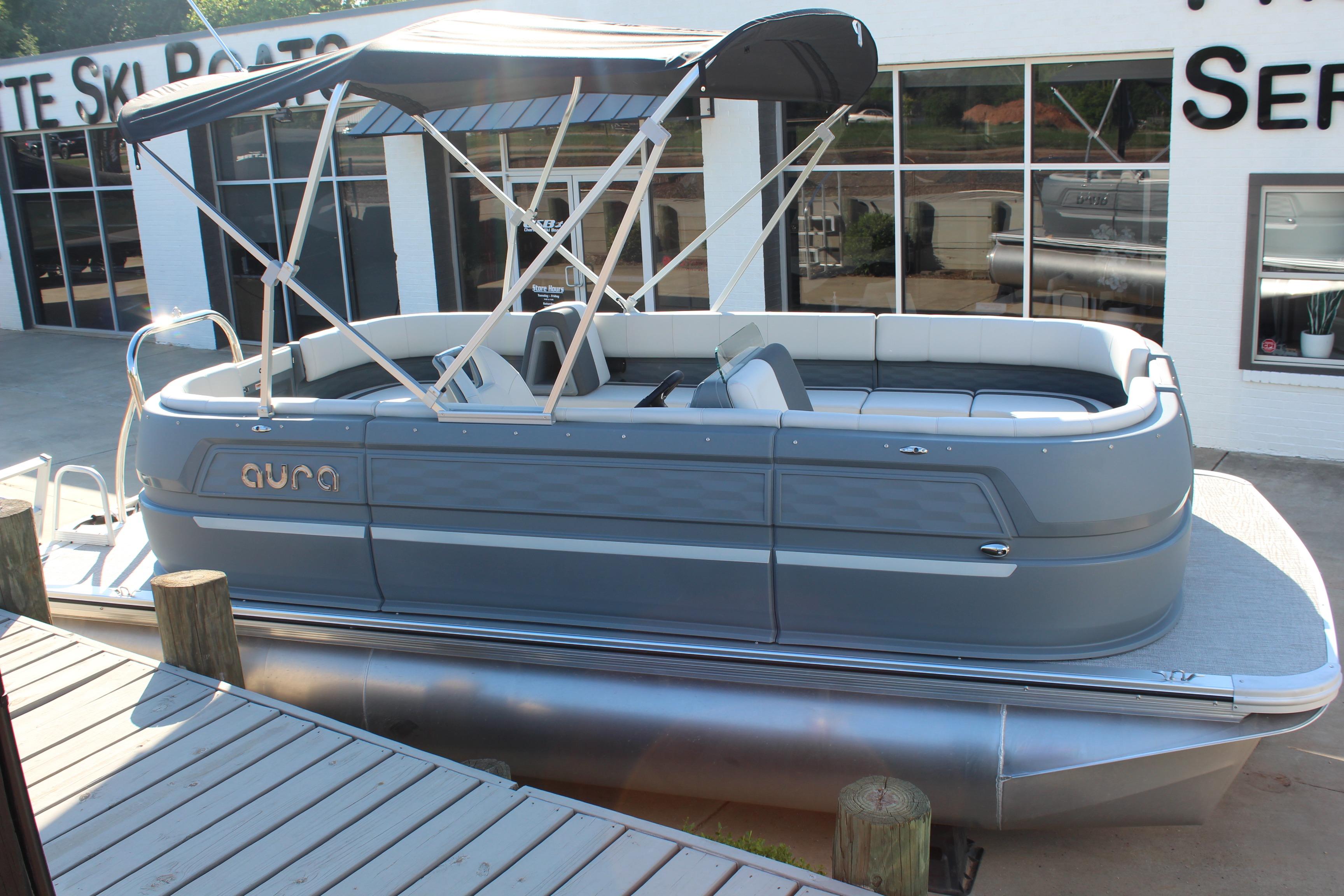 2026 Tahoe Pontoon Aura boat with canopy, docked outside a service center.