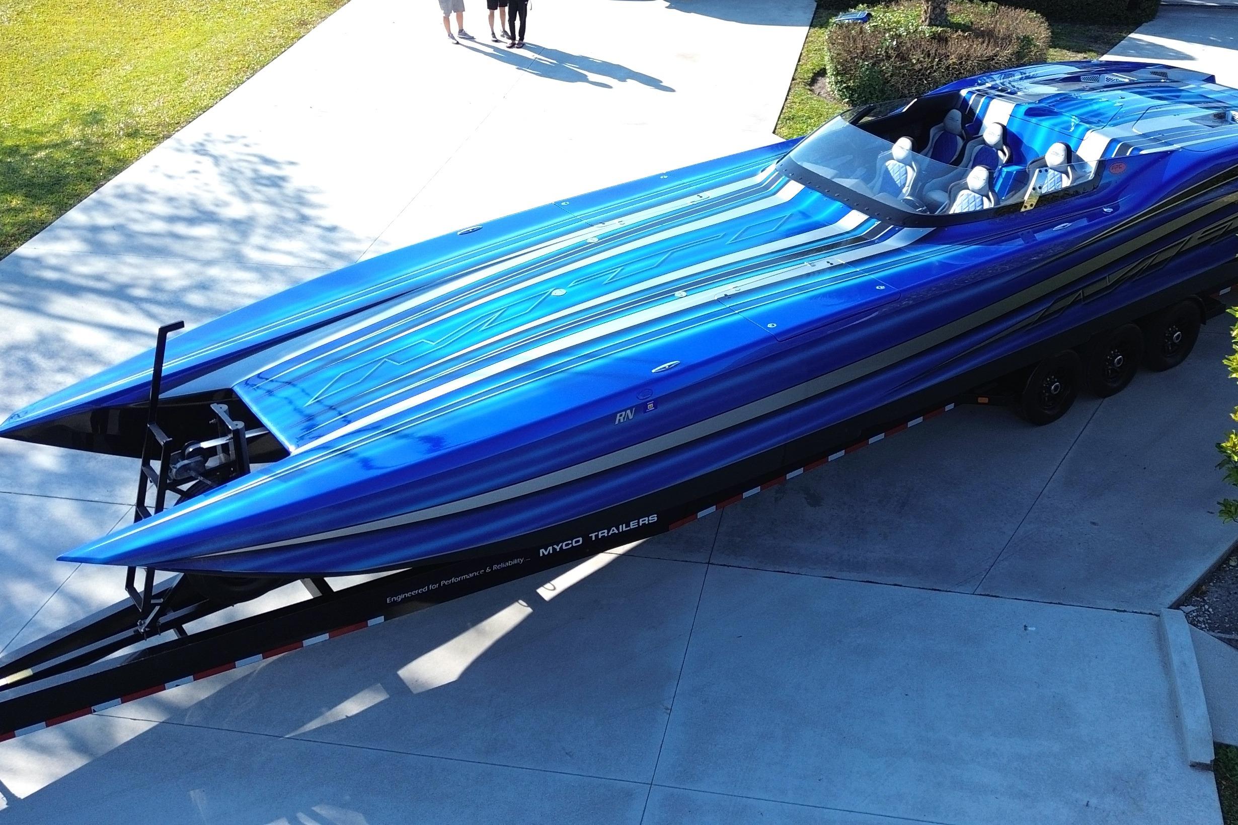 2016 MTI 44 RP speedboat in vibrant blue on a trailer, parked on a driveway.