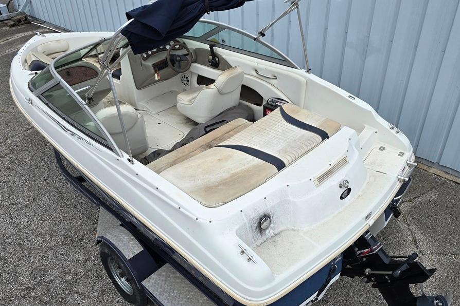 2003 Caravelle 187 Bow Rider boat with white interior and steering wheel, parked on a trailer.