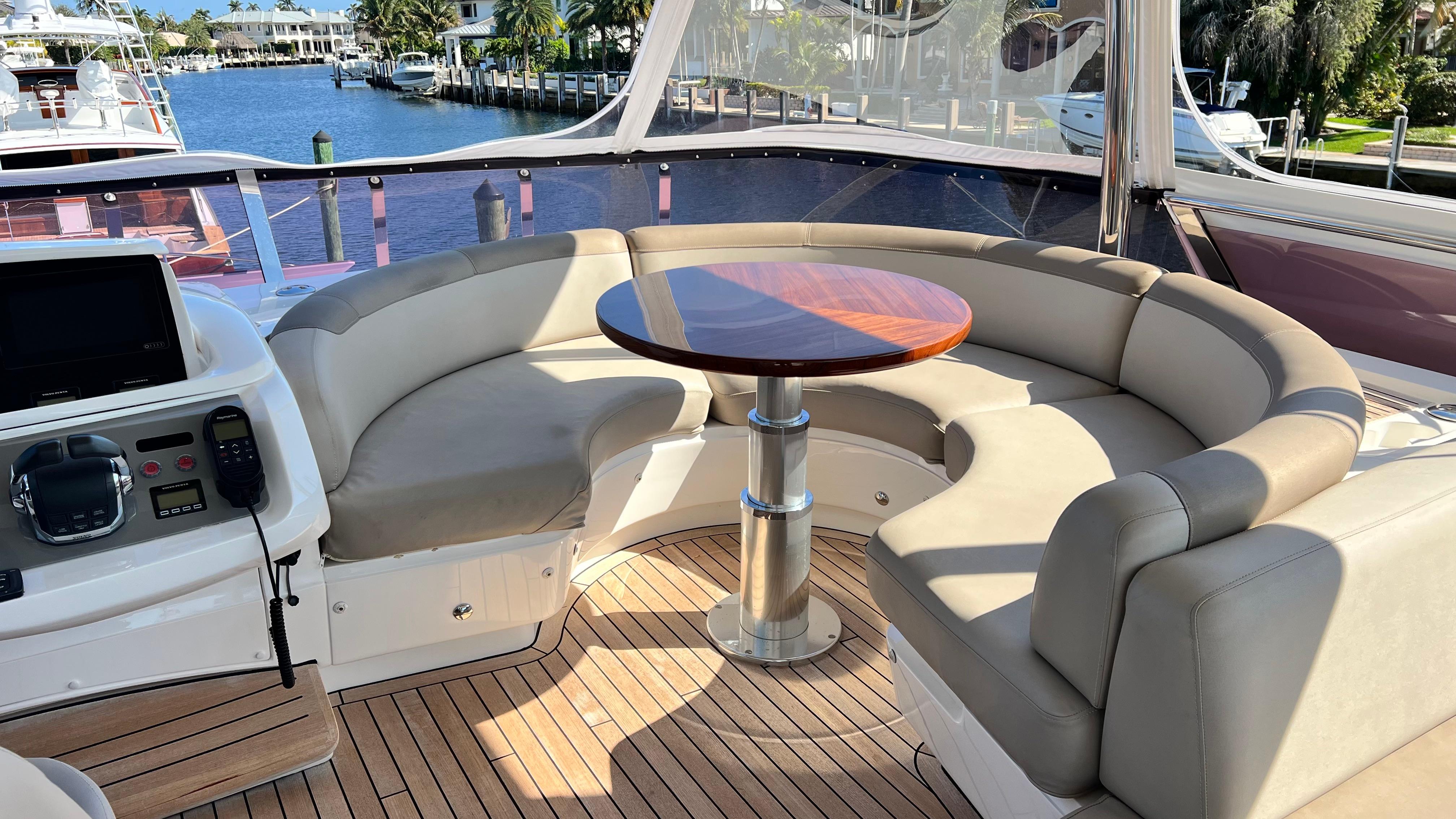 Luxurious seating area on a 2019 Princess F62 yacht with a wooden table.