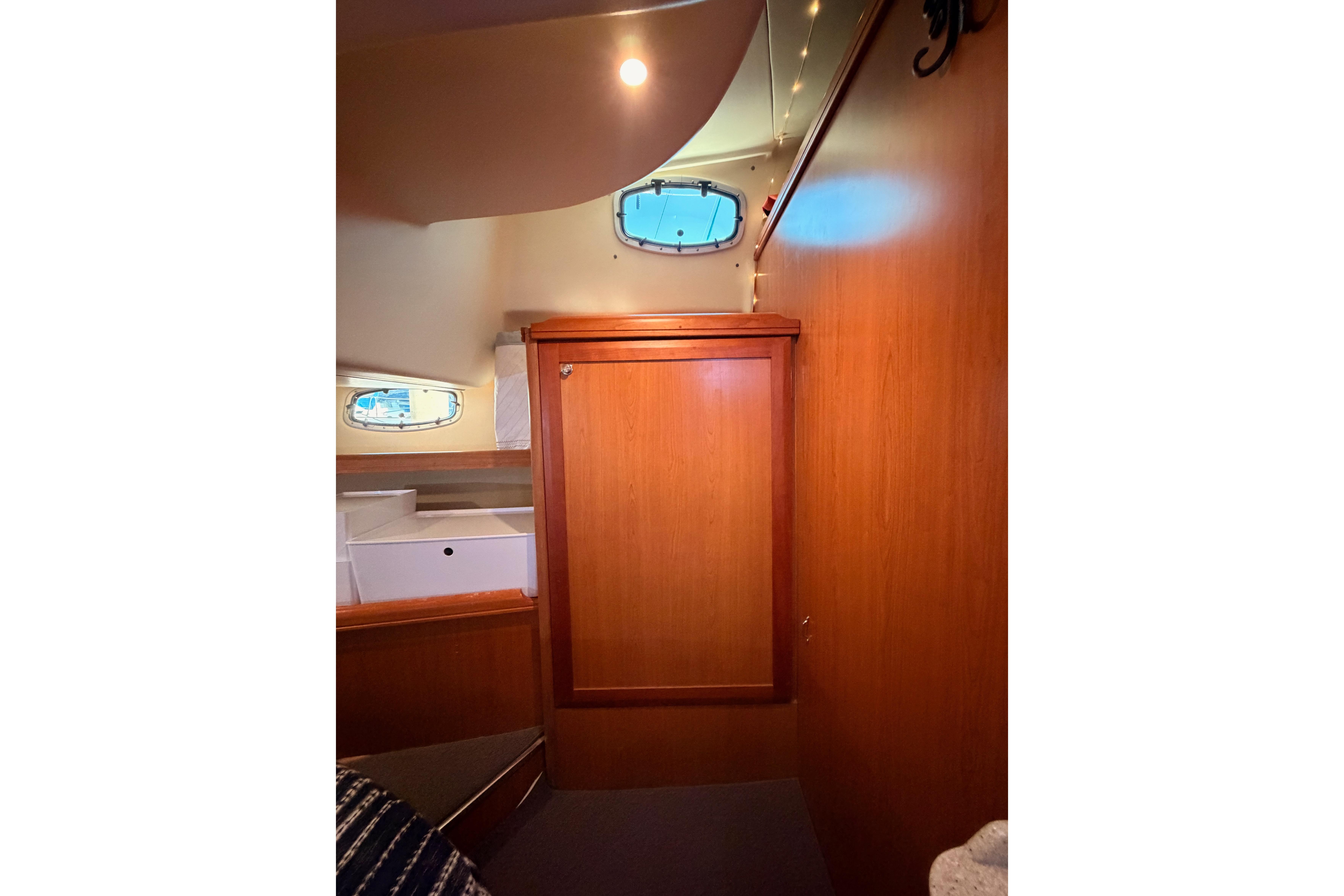 Interior of 2008 Hunter 45 Deck Salon with wooden cabinetry and porthole window.