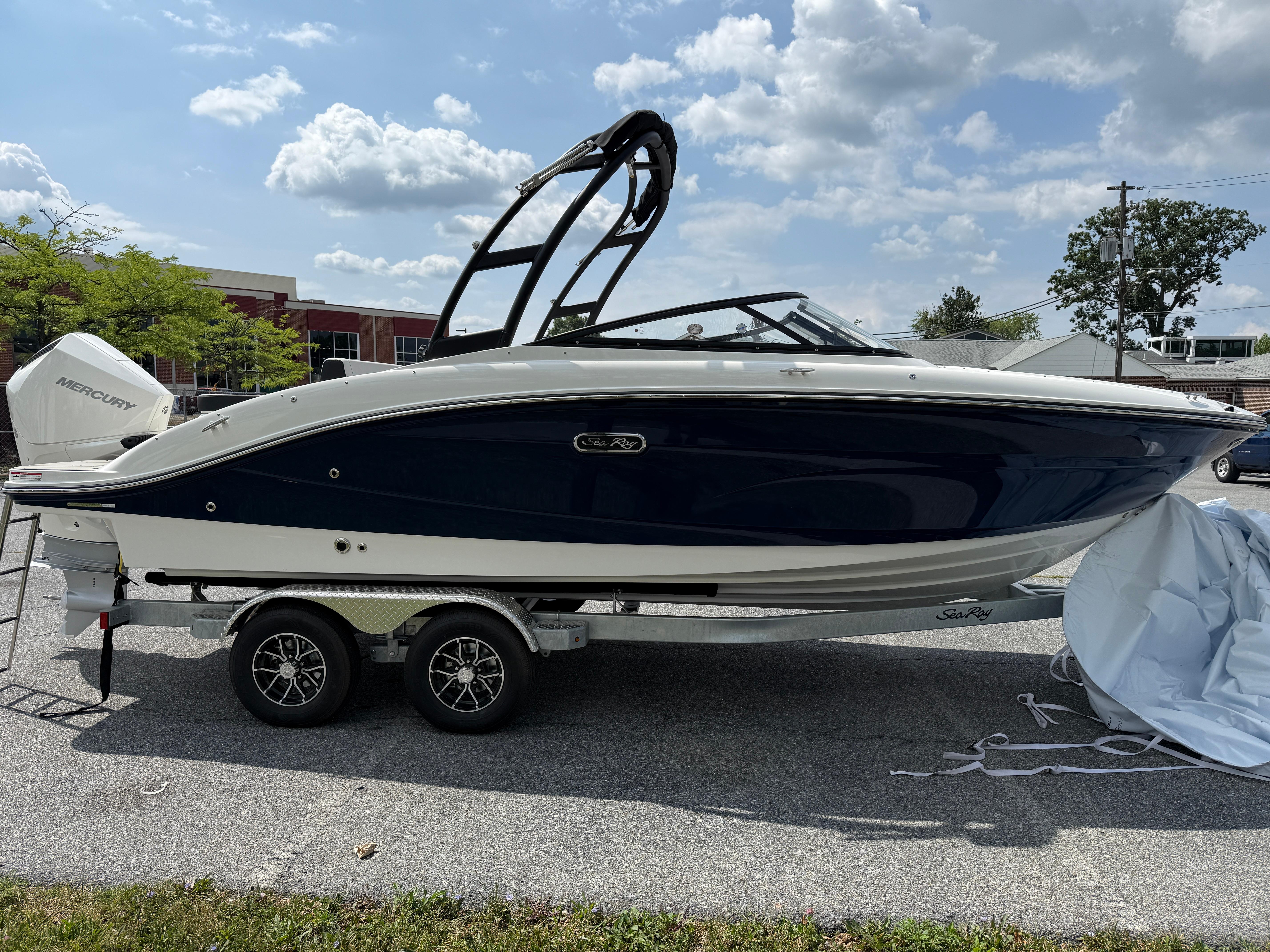 2026 Sea Ray SPX 210 Outboard boat on trailer, parked outdoors under a cloudy sky.