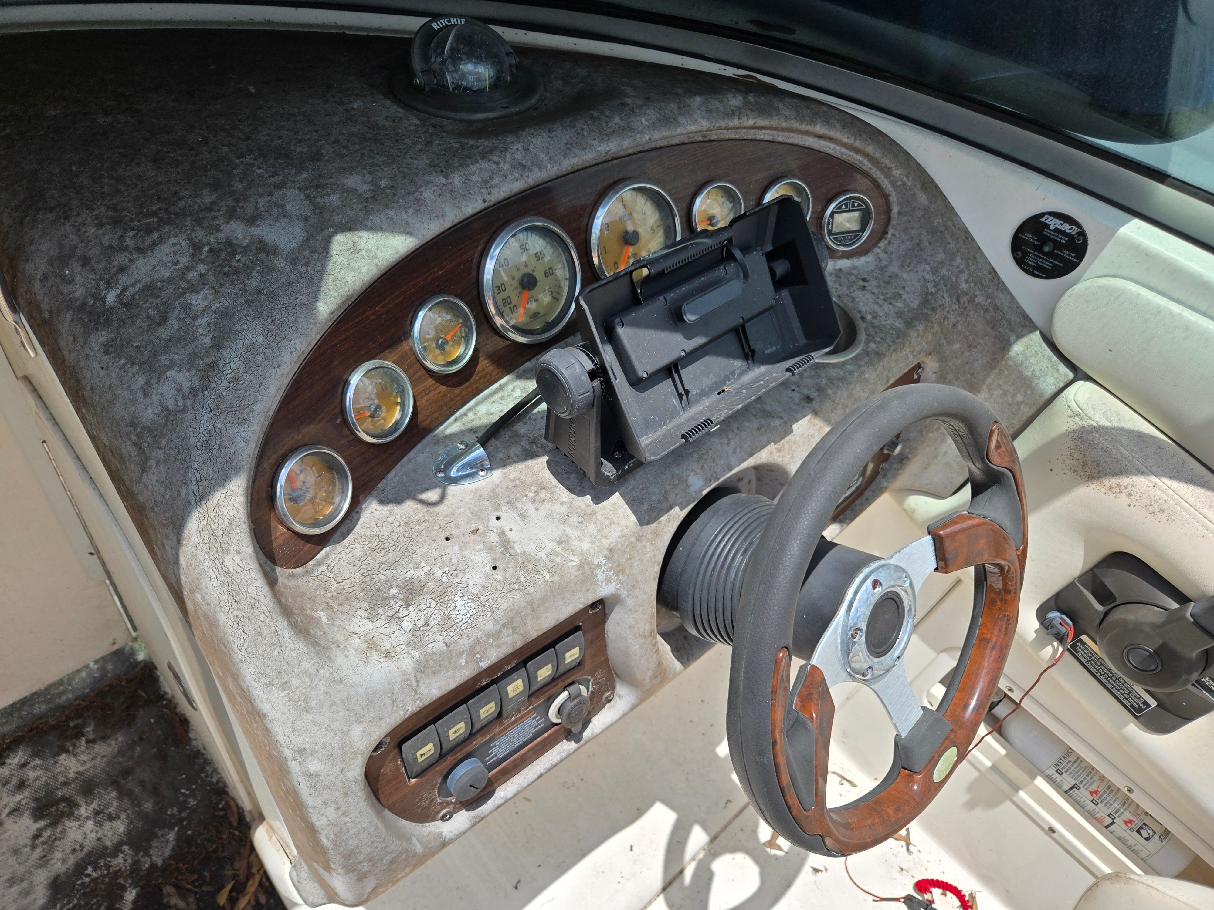 Dashboard of a 2006 Chaparral 220 SSi with a worn steering wheel and instruments.