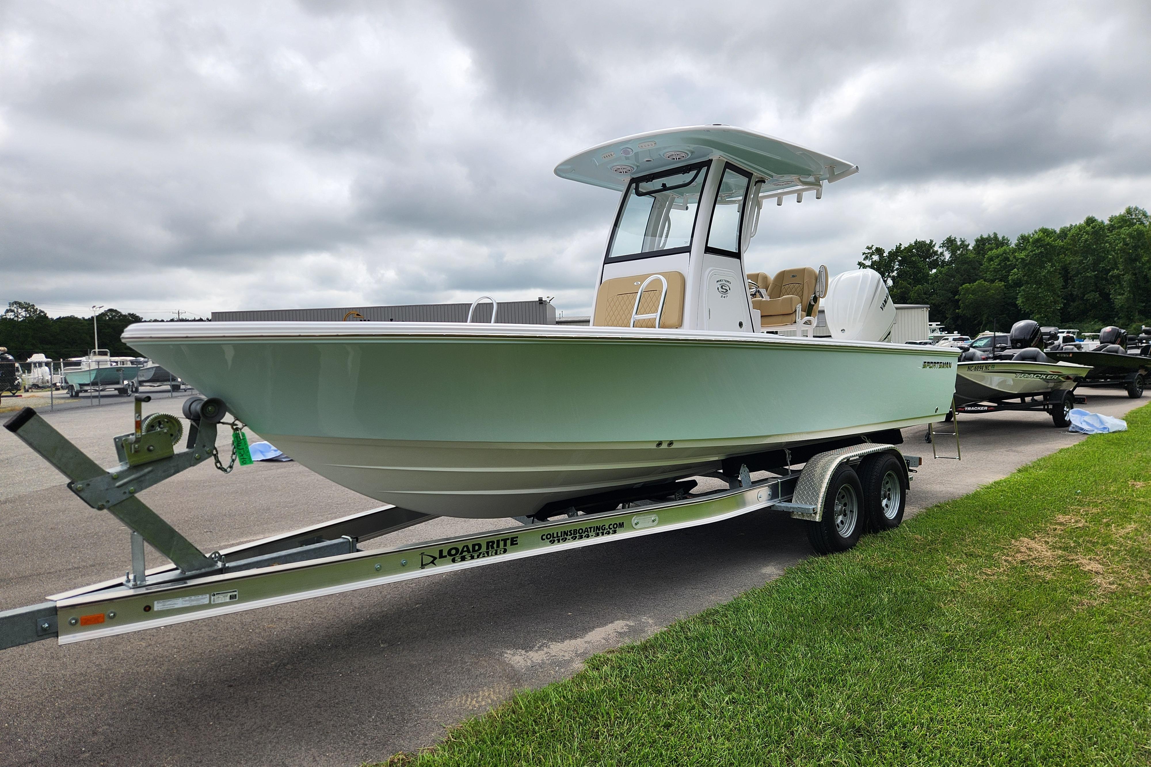 2026 Sportsman Masters 247 Bay Boat on trailer, parked outdoors under cloudy sky.