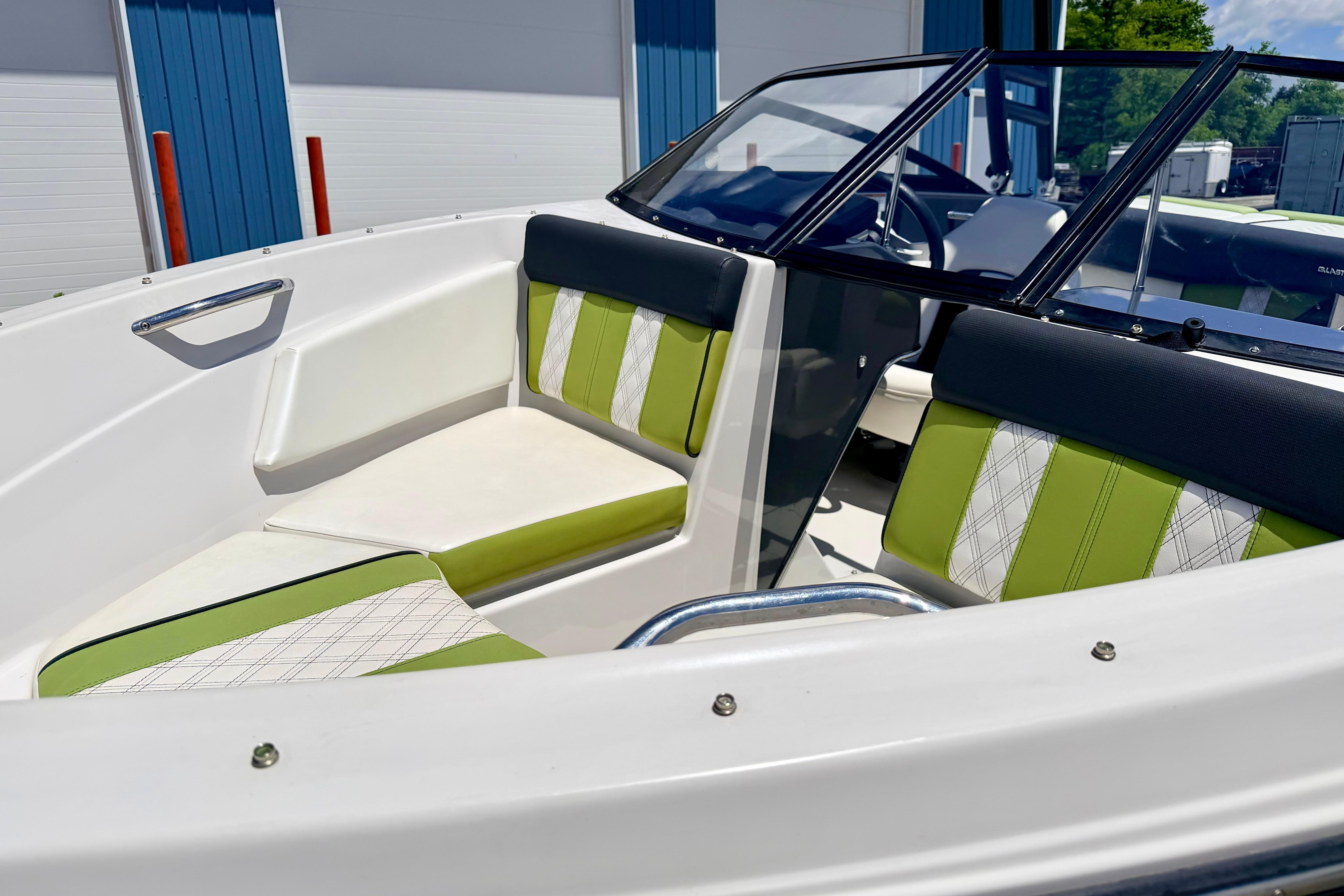 2018 Glastron GT 185 boat interior with green and white seating, docked outdoors.
