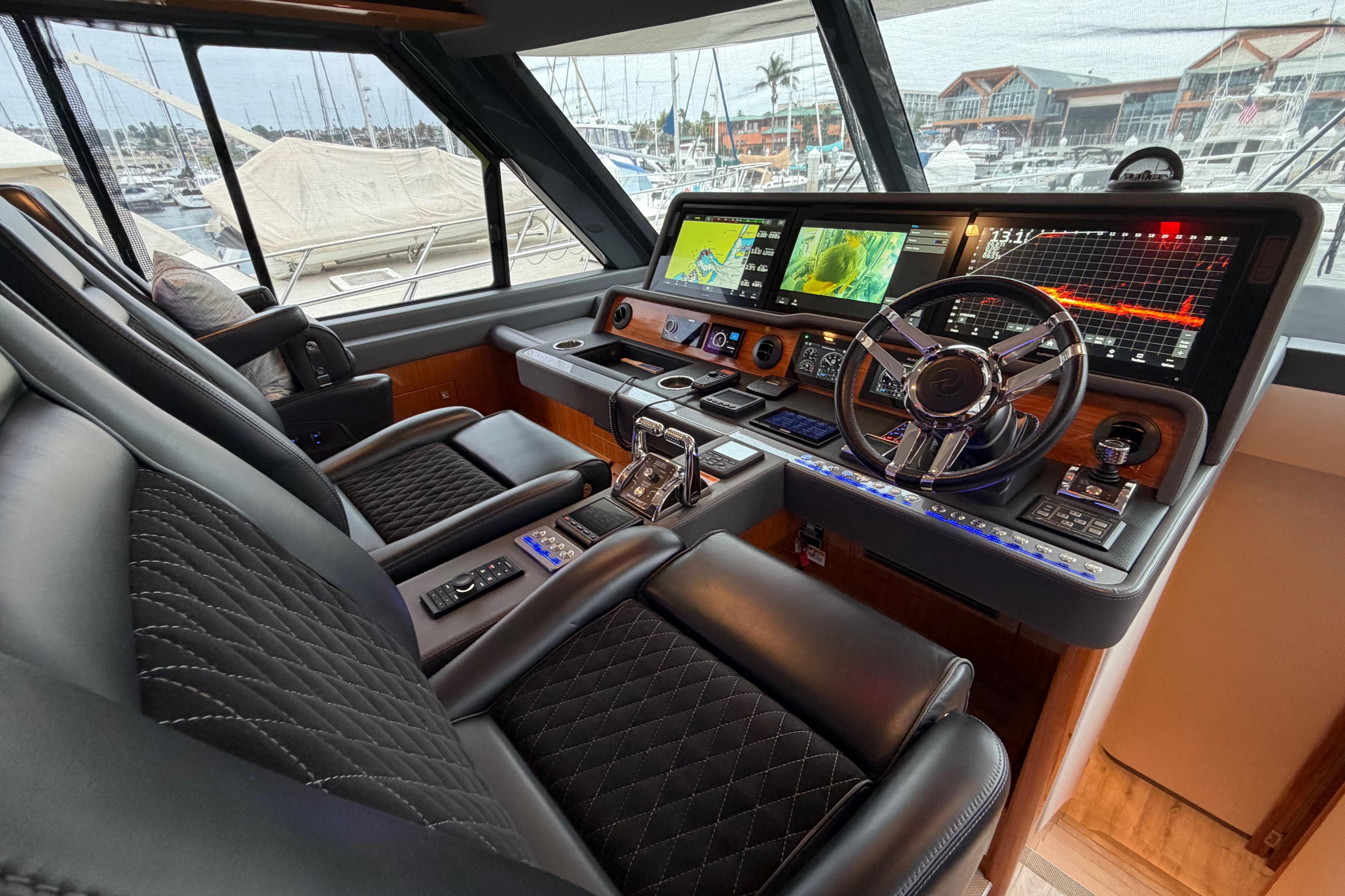 Luxurious 2023 Riviera 645 SUV yacht cockpit with advanced navigation systems and plush seating.
