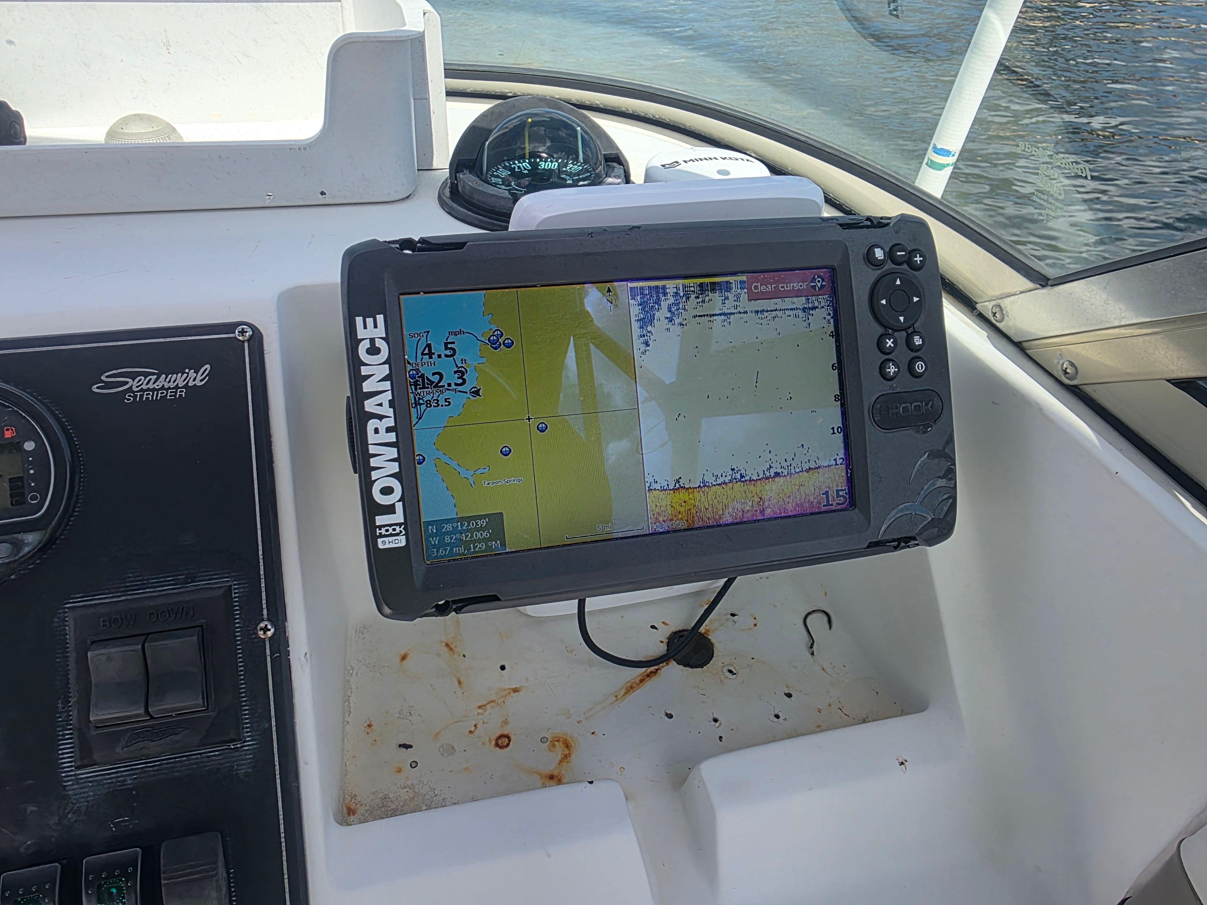 A Lowrance fish finder is mounted on a boat, displaying depth information on the screen.