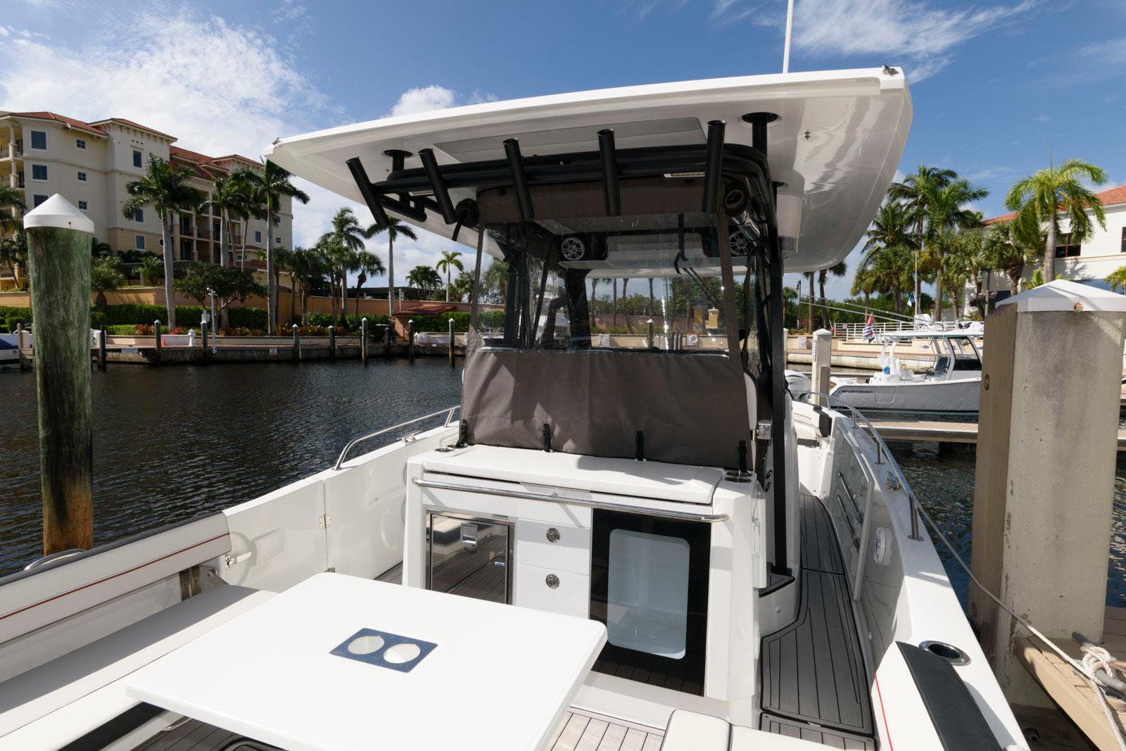 2023 Jeanneau Leader 10.5 CC boat docked in a marina under a clear sky.
