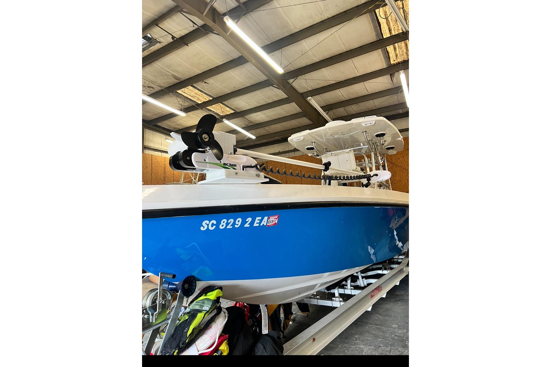 2021 Custom Infusion 34 CC boat in a warehouse, blue hull, visible registration number.