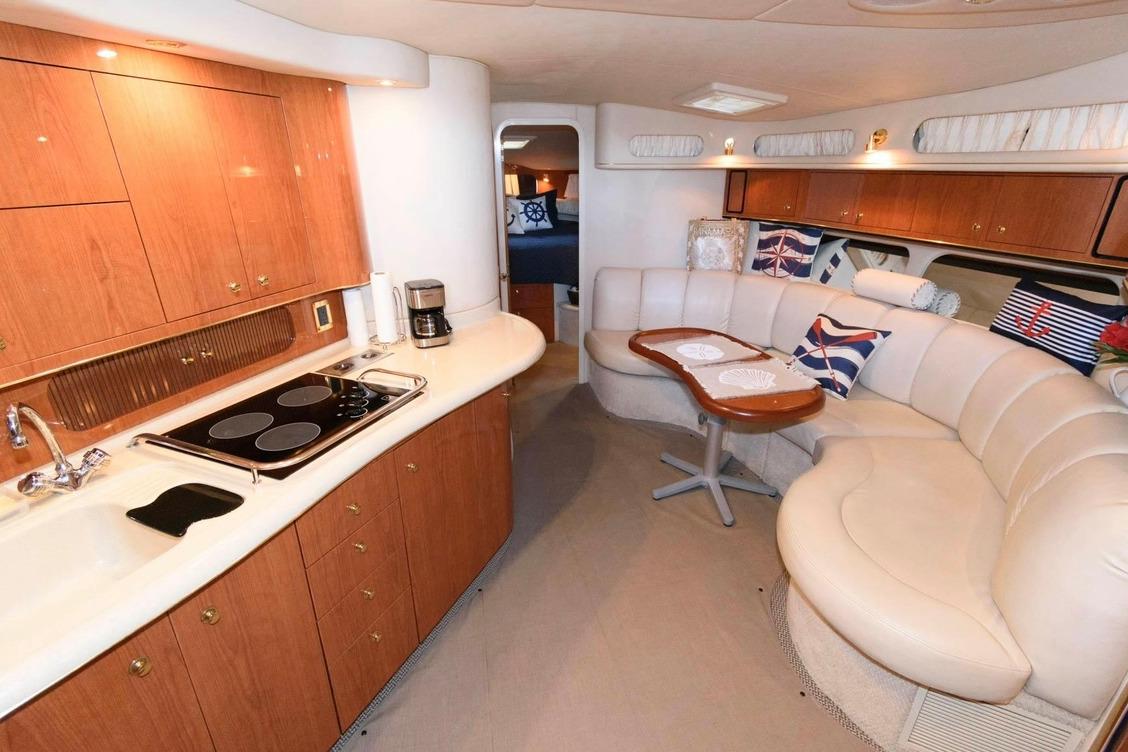 Luxurious interior of 1999 Sea Ray Sundancer 400 yacht with kitchen and seating area.