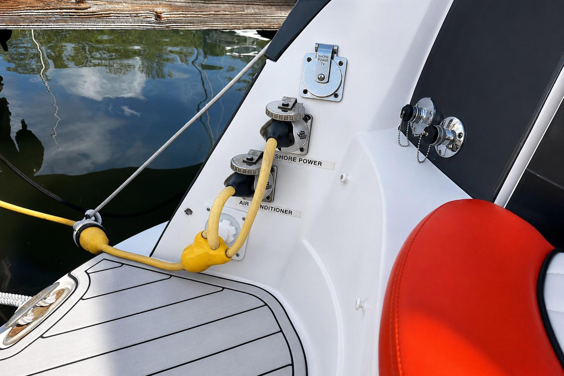 2012 Rinker 310 Express Cruiser LE shore power connections with yellow cables and red seating.