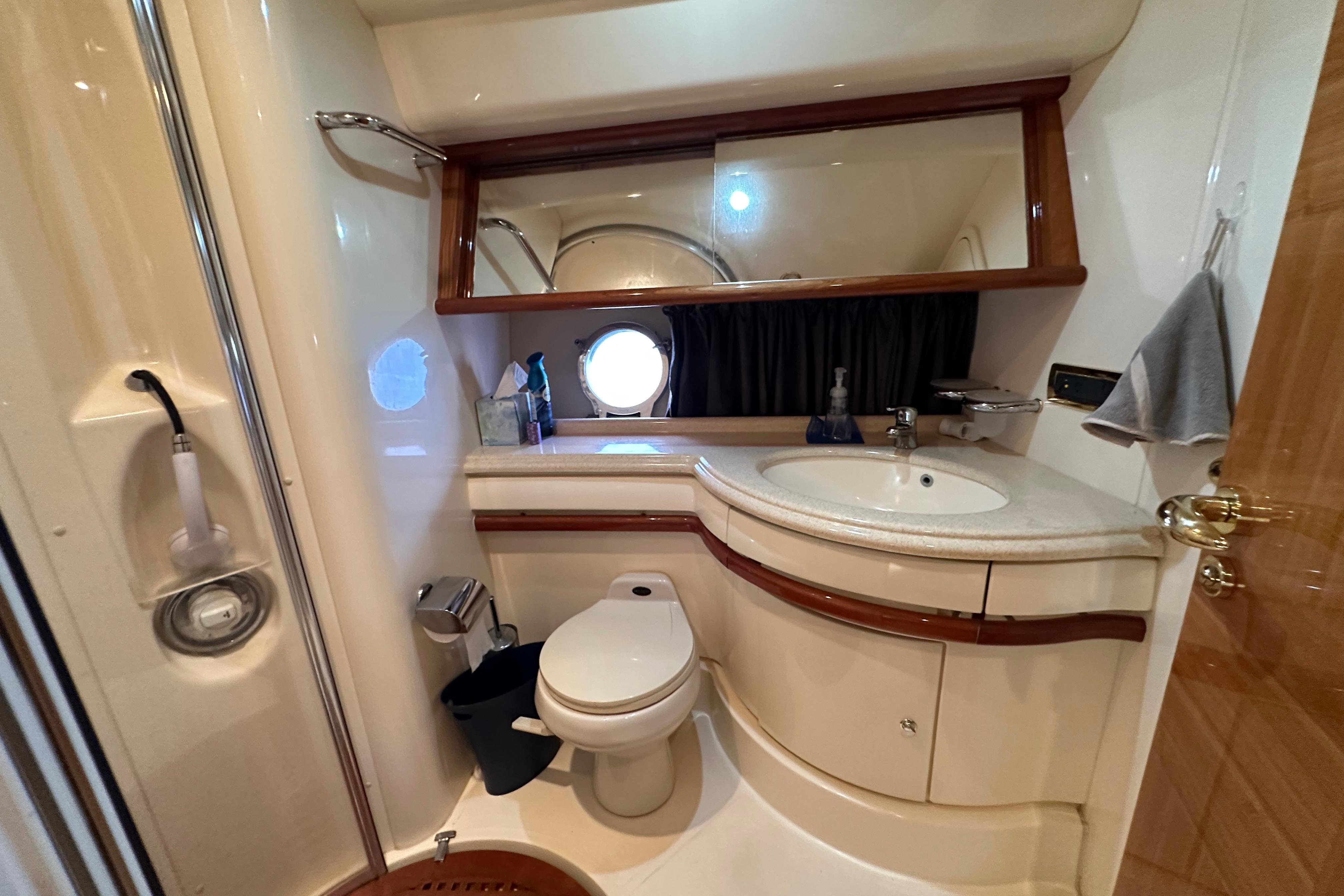 Luxurious bathroom interior of 2004 Azimut 55E yacht with modern fixtures and porthole.