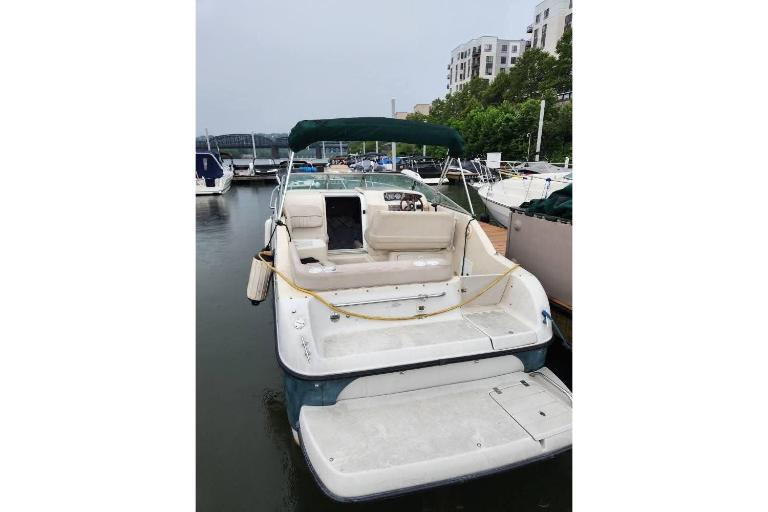 2001 Crownline 242 CR boat docked at marina, featuring spacious seating and canopy.