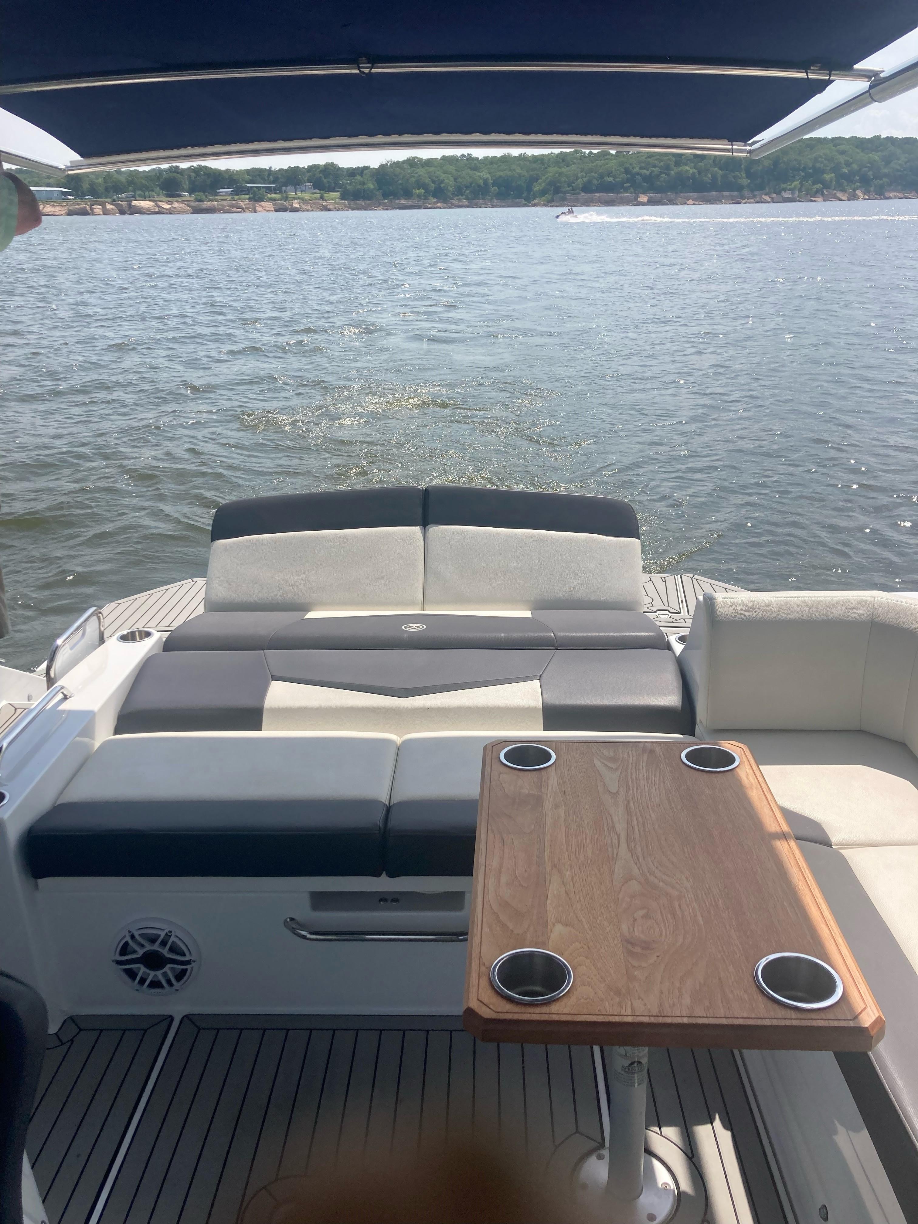 2019 Cruisers Yachts 338 interior with seating and table, overlooking calm waters.