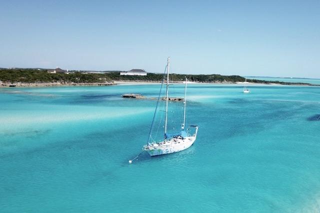 Sailboat "Vahalia" by ALPHA MARINE (1979) in turquoise waters near a lush coastline.