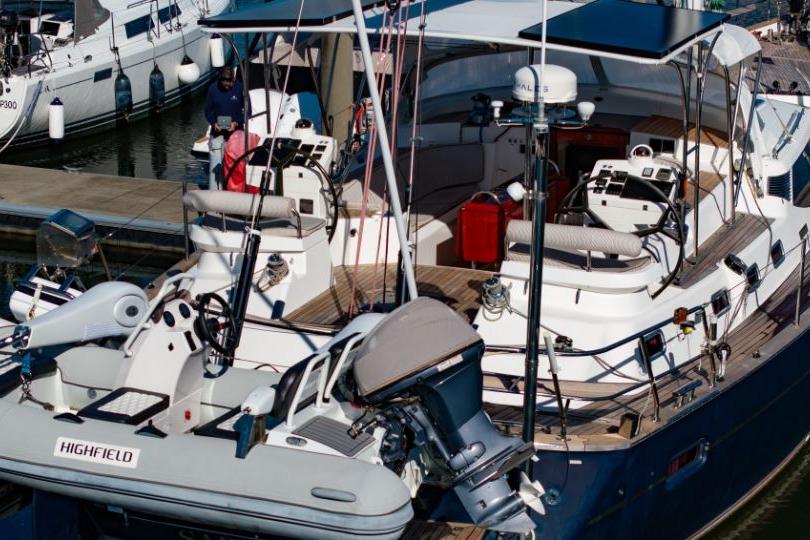 Luxury Discovery 67 yacht from 2011 docked with inflatable boat attached.