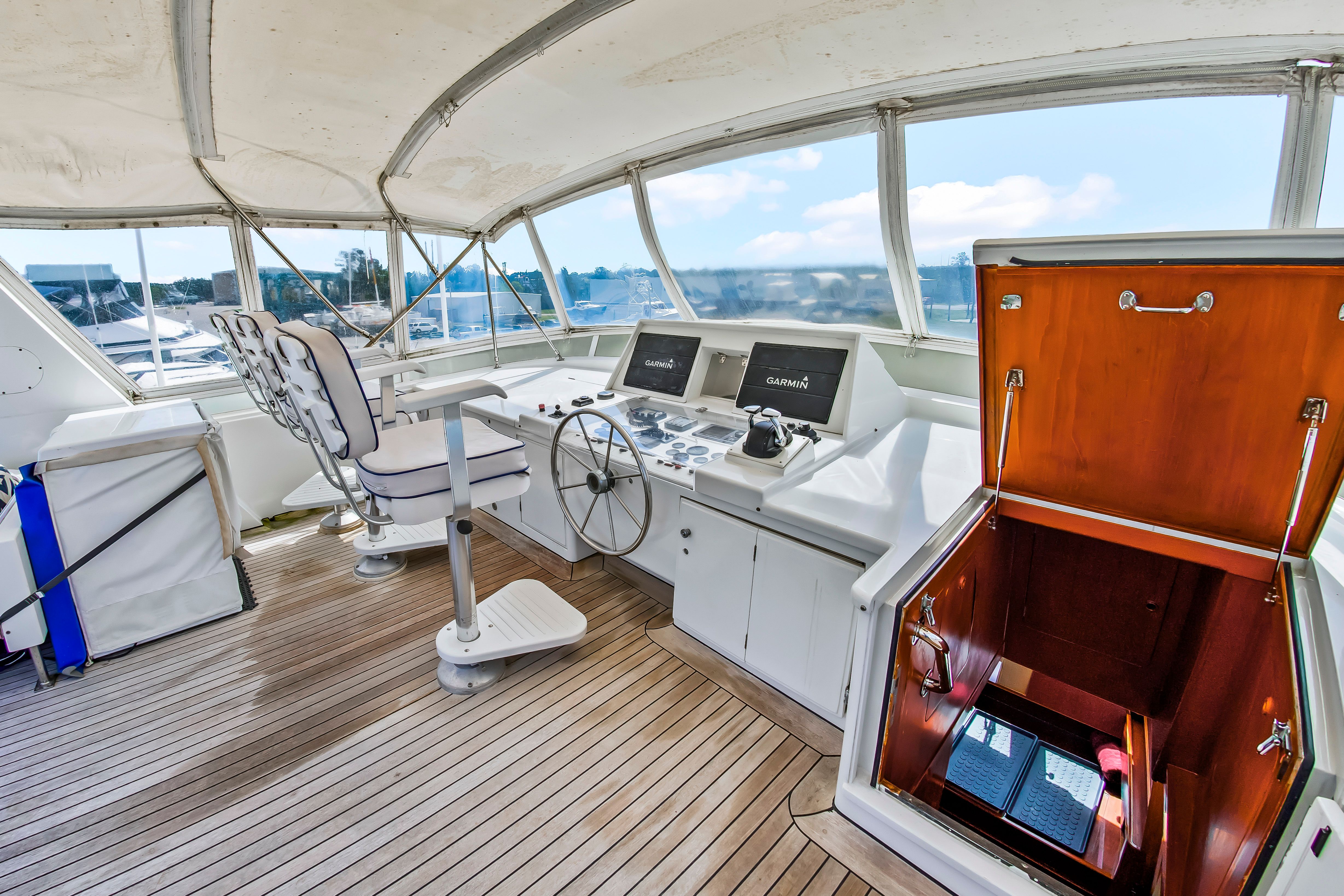 Helm of a 1987 Jongert 78 Motor Yacht with wooden flooring and modern electronics.