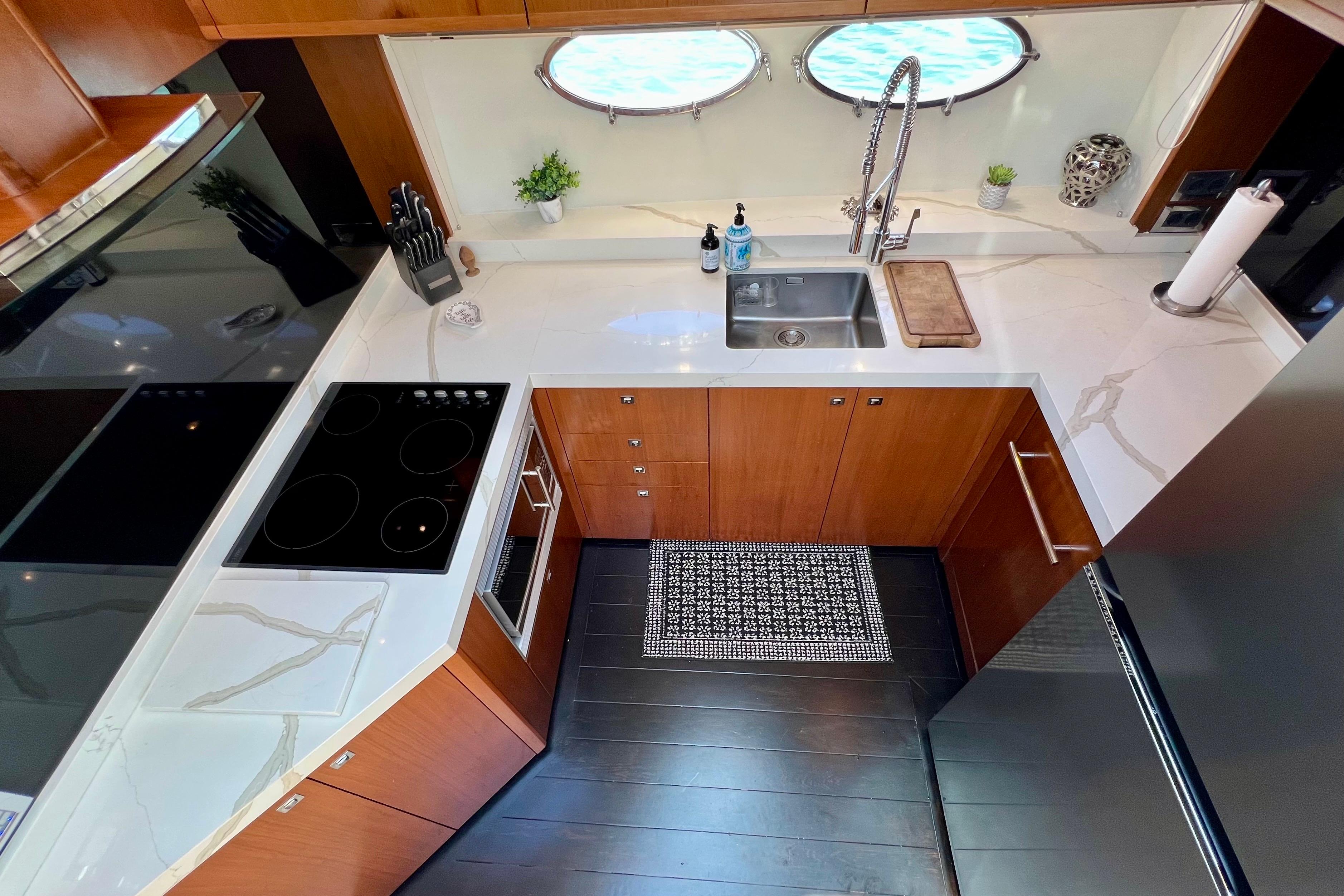 Modern kitchen in 2010 Princess V78 yacht with sleek countertops and appliances.