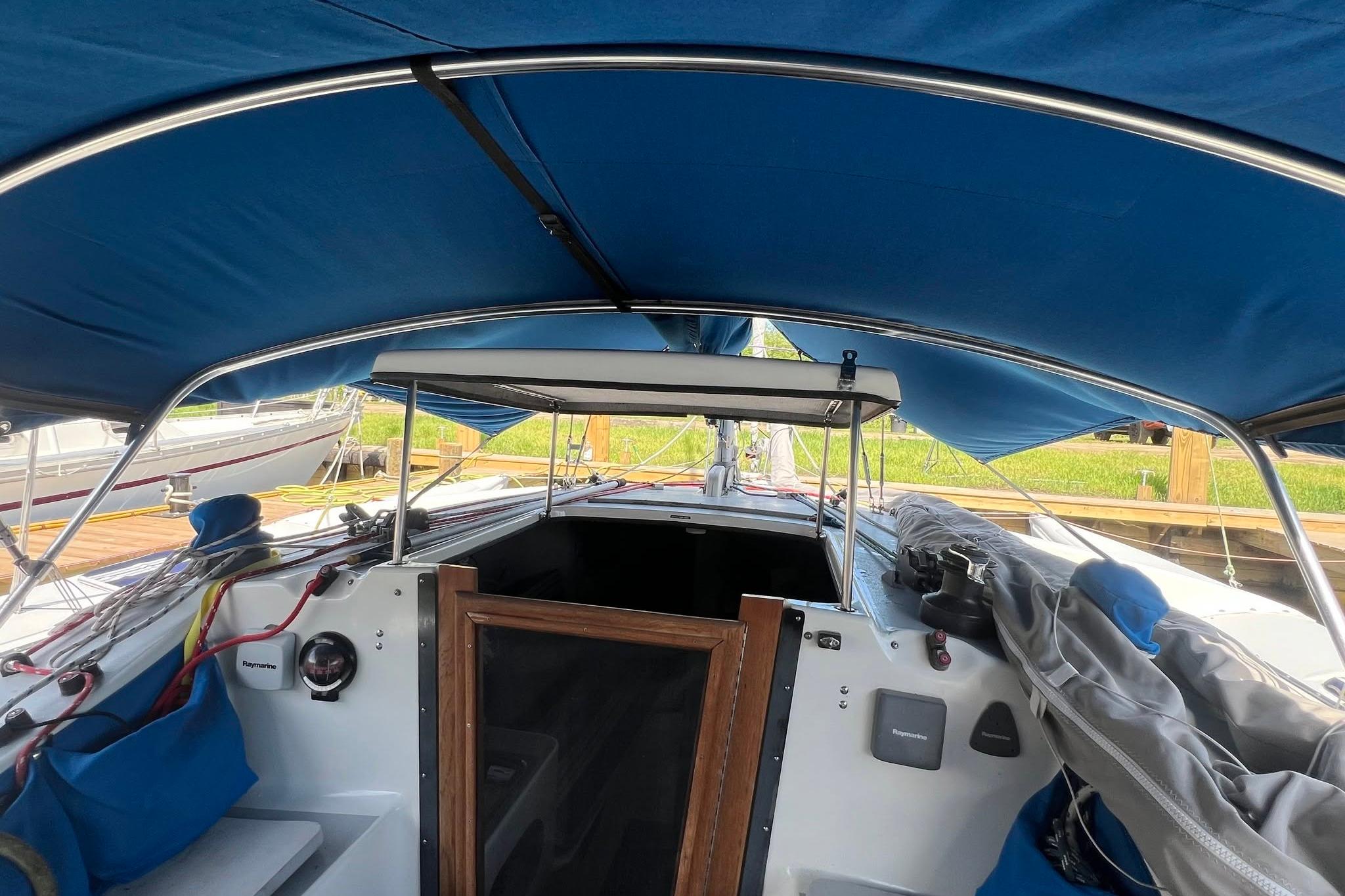Cockpit view of a 1993 Corsair F-27 sailboat with blue canopy.