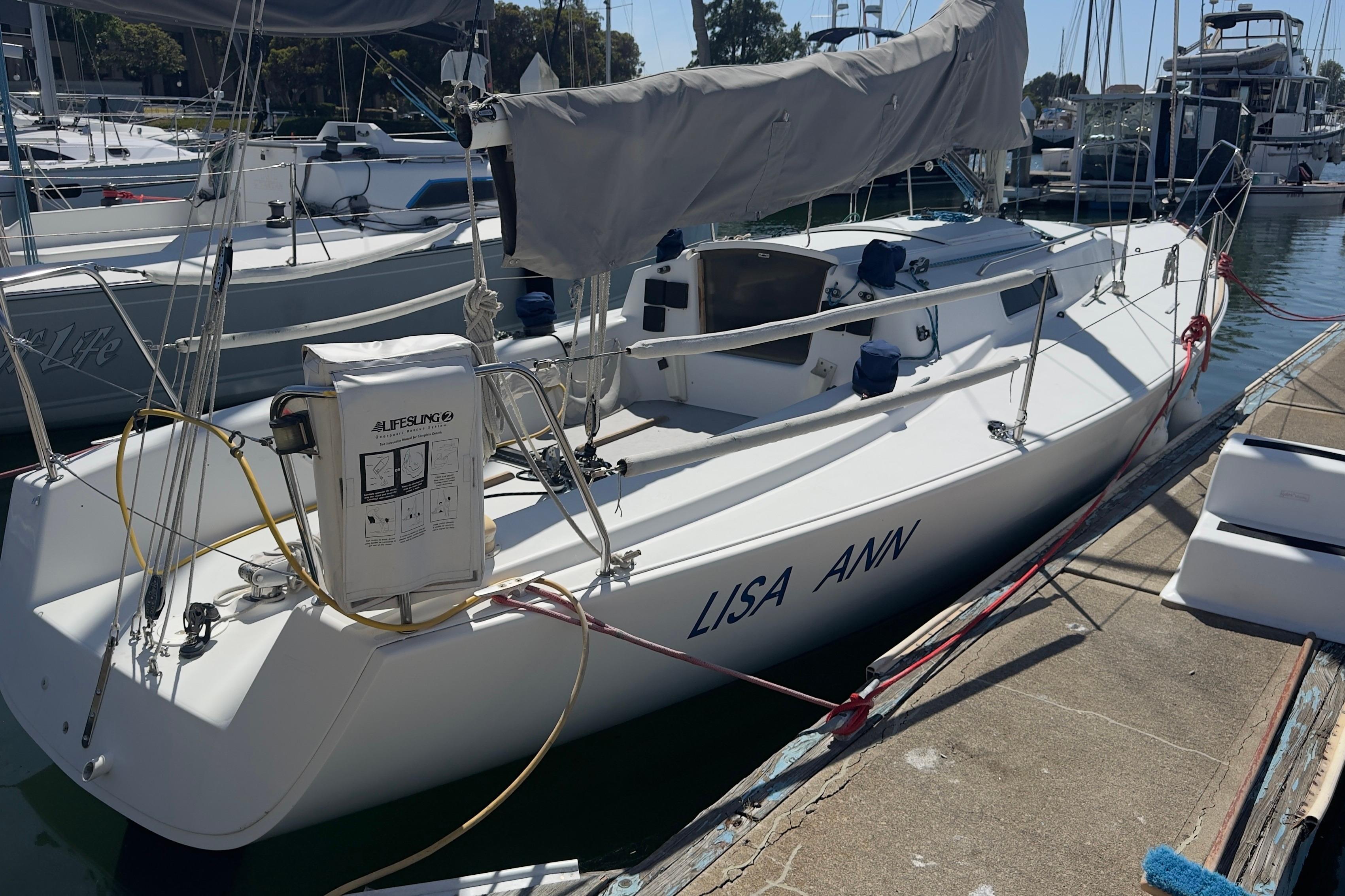 1994 J Boats J/92 sailboat docked, named "Lisa Ann," with covered sails and lifebuoy.