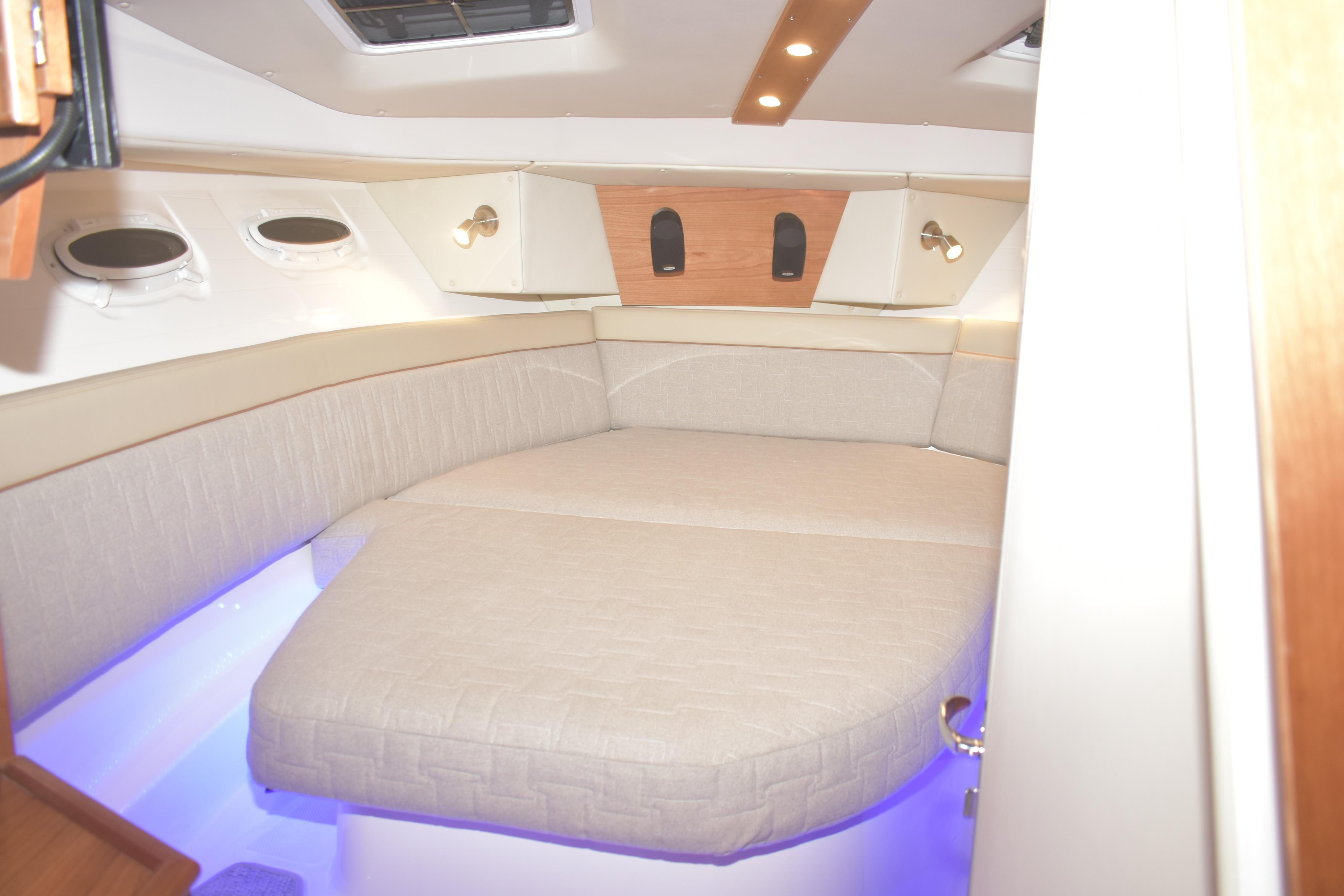 2026 Cutwater C-32 CB cabin interior with cozy bed and ambient lighting.