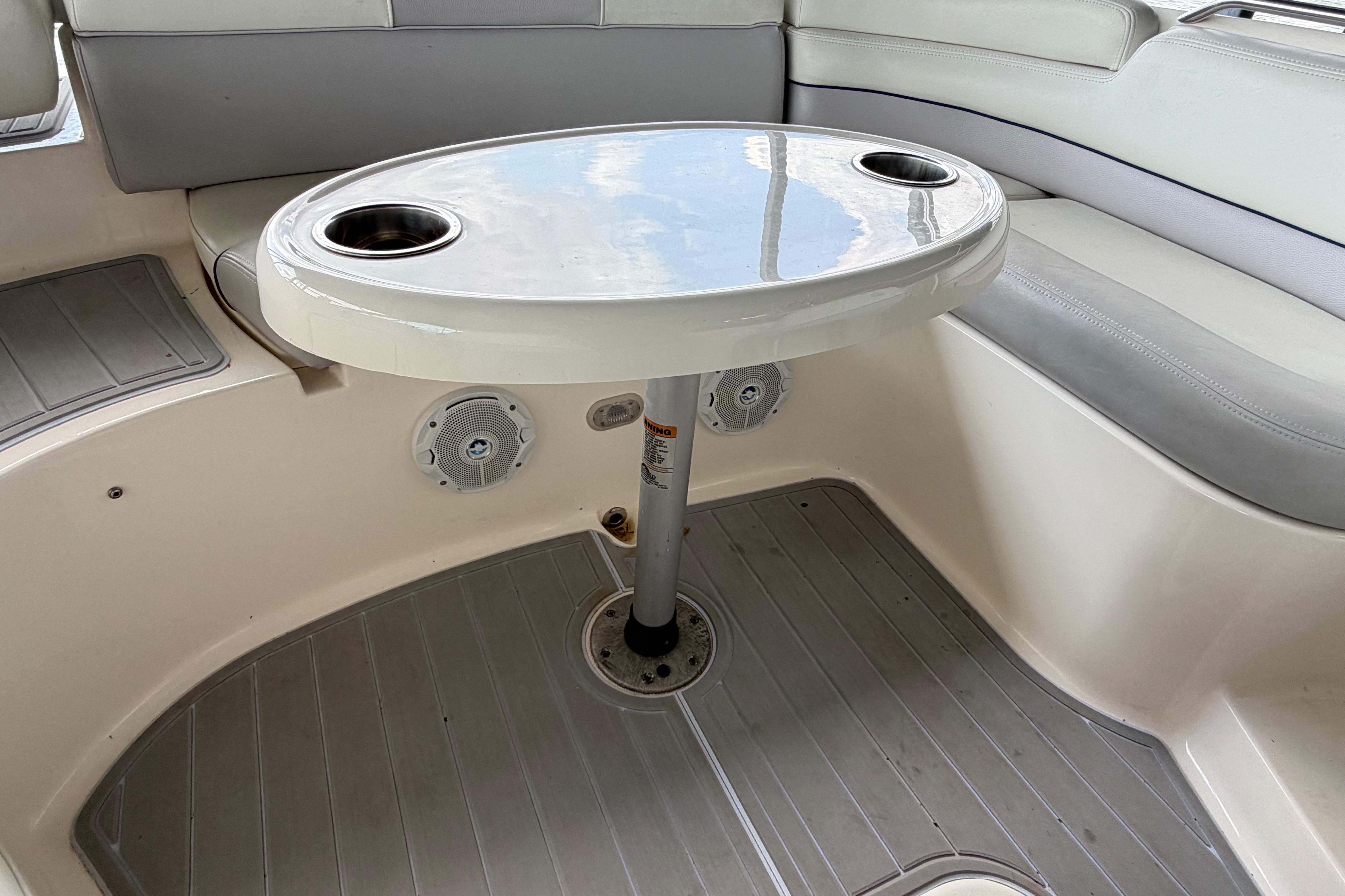 Interior of a 2010 Bryant 255 boat featuring a table with cup holders.