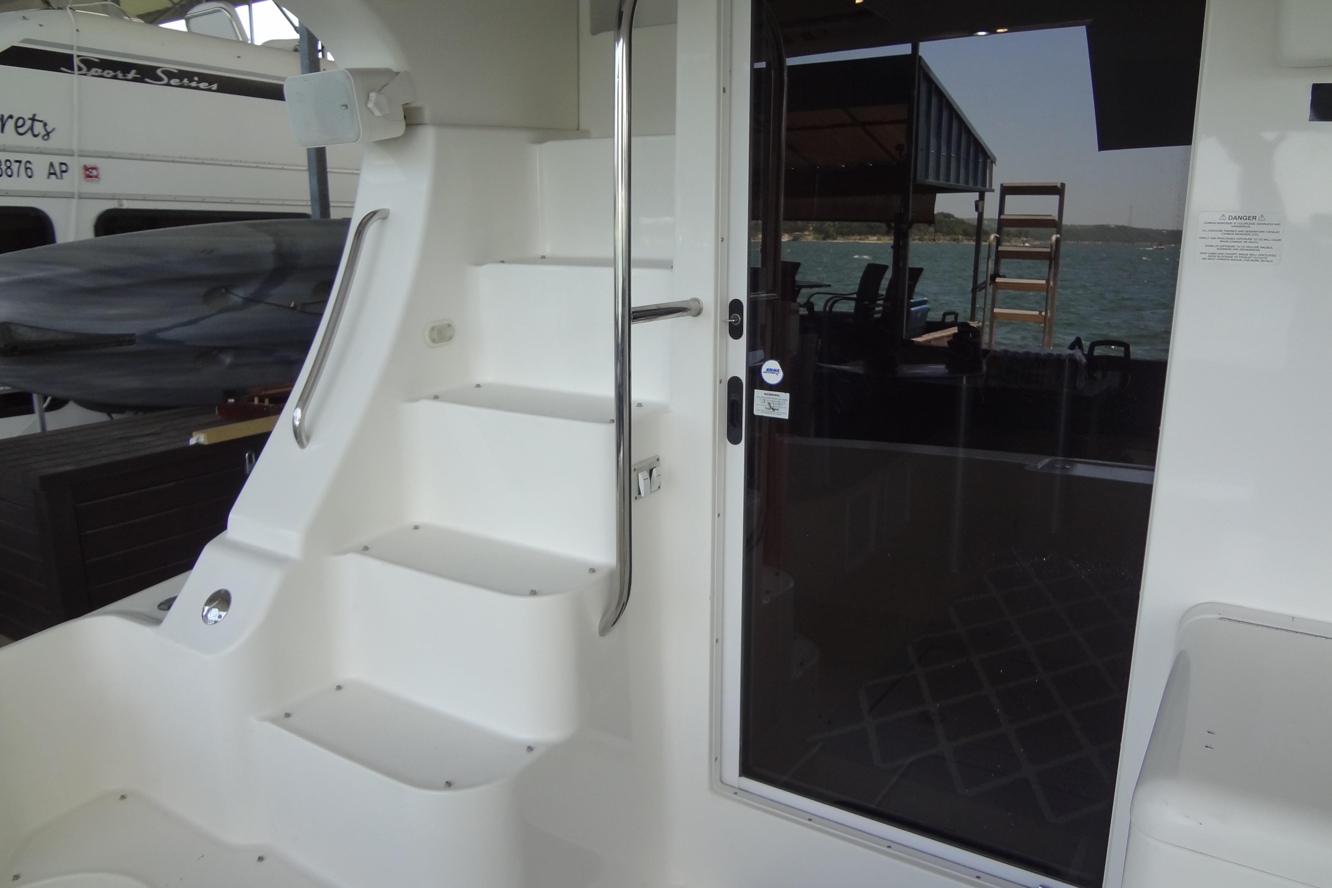 2005 Silverton 34 Convertible yacht interior with stairs and glass door, docked by the water.