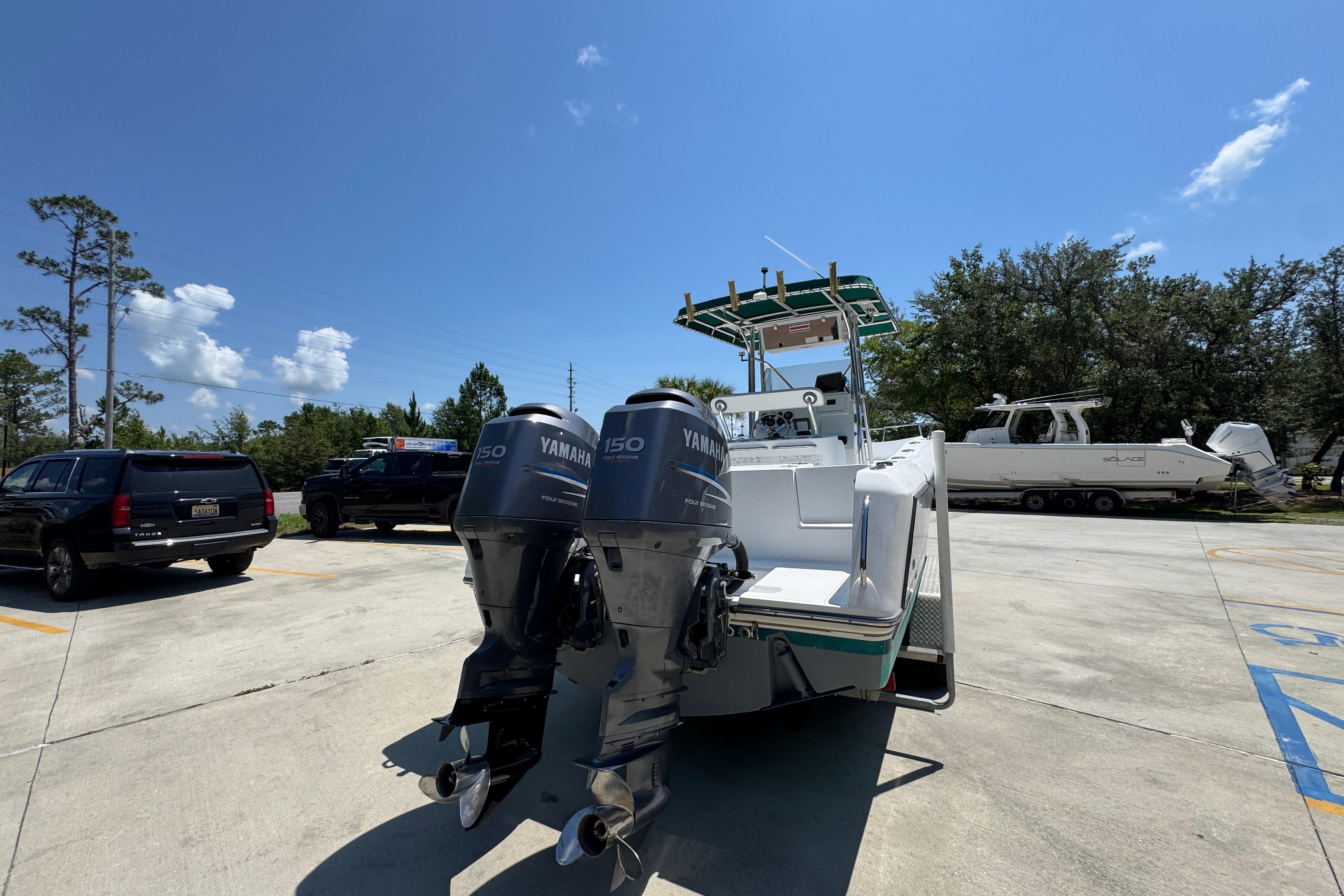 2000 Stamas 250 Tarpon boat with dual Yamaha 150 engines in a parking lot.