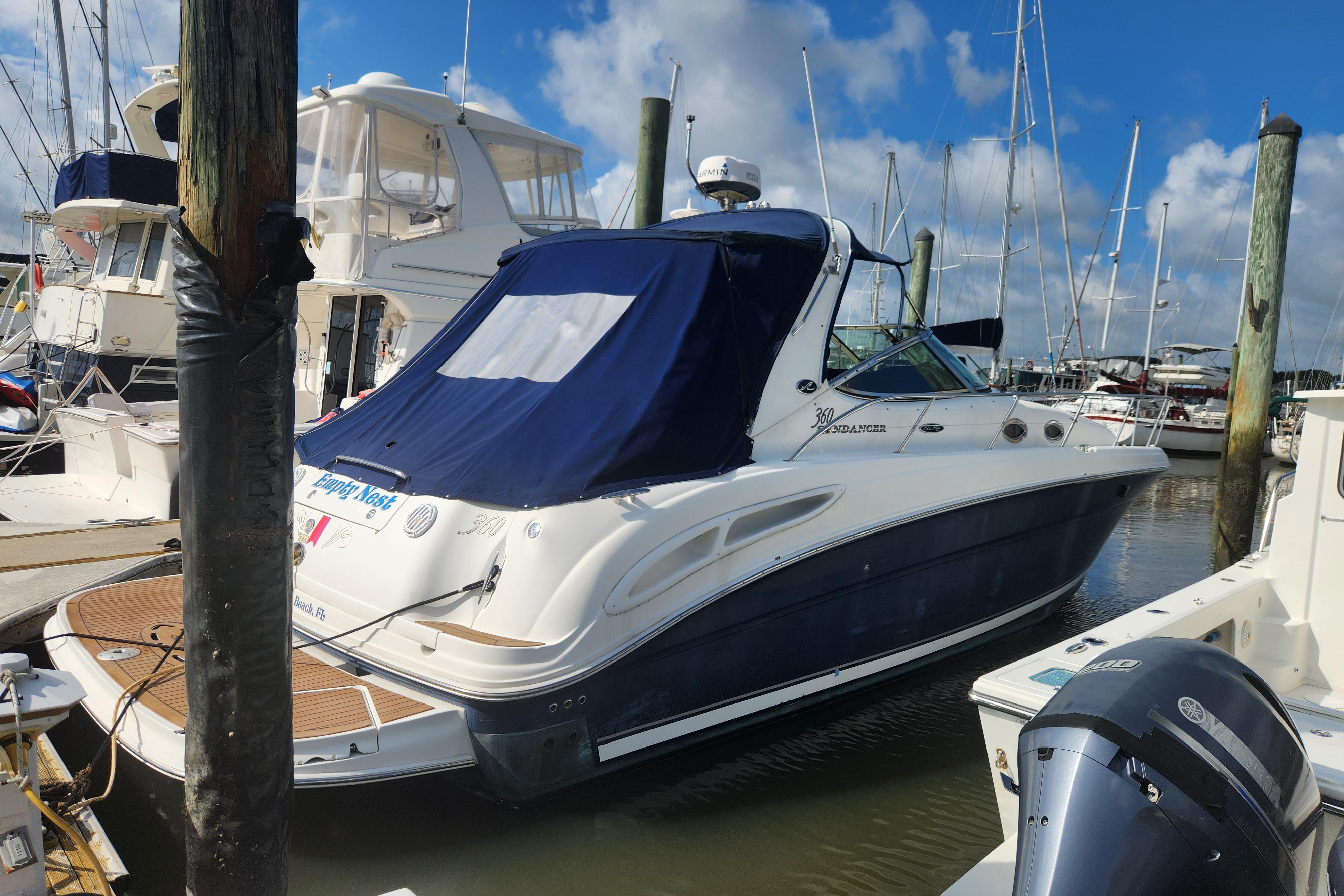 2003 Sea Ray 360 Sundancer yacht docked at marina under blue sky.