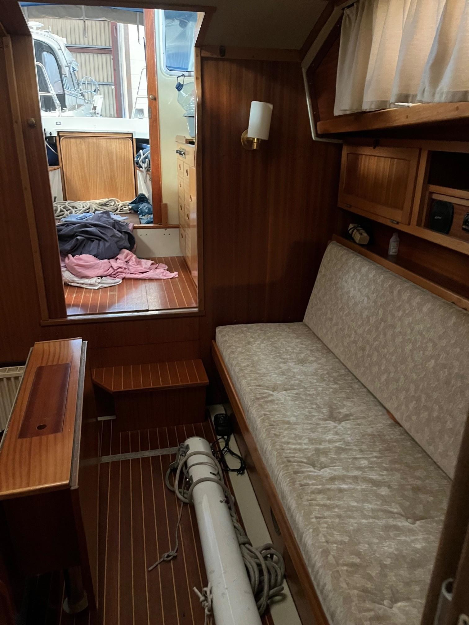 1980 LM 32 boat interior with wooden paneling and cushioned seating.