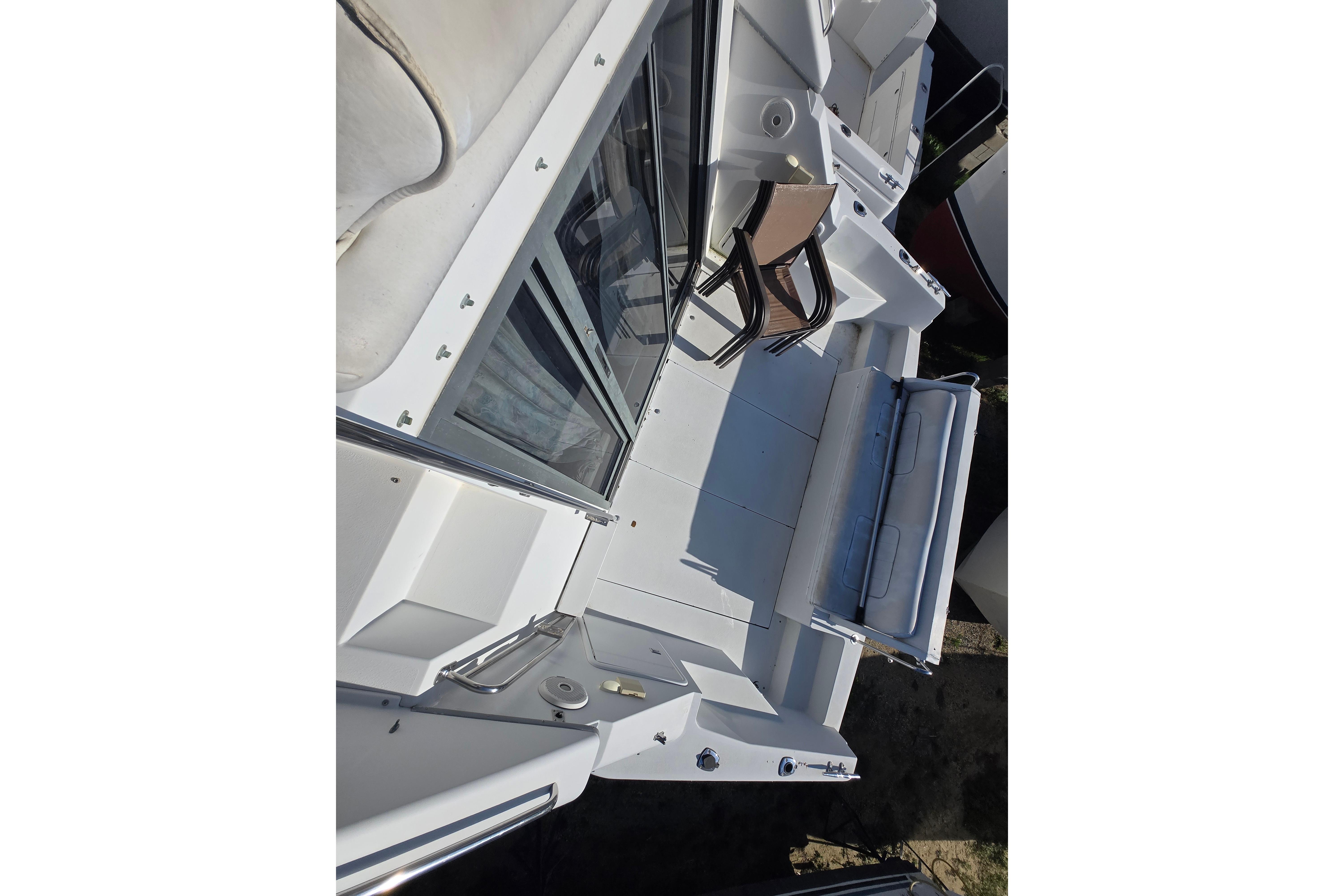 1994 Carver 380 Santego yacht deck with seating and glass doors.