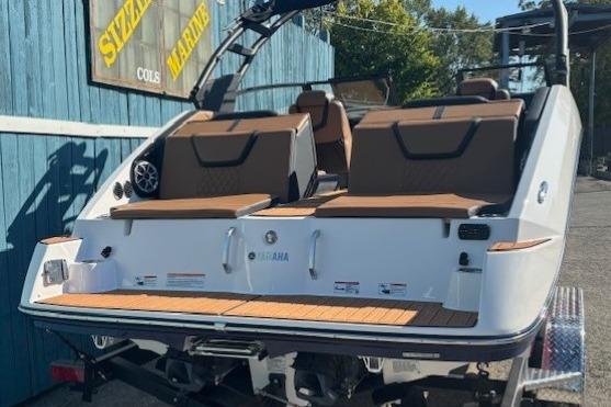 2026 Yamaha Boats 222SE with brown seating, displayed outdoors at a marine dealership.