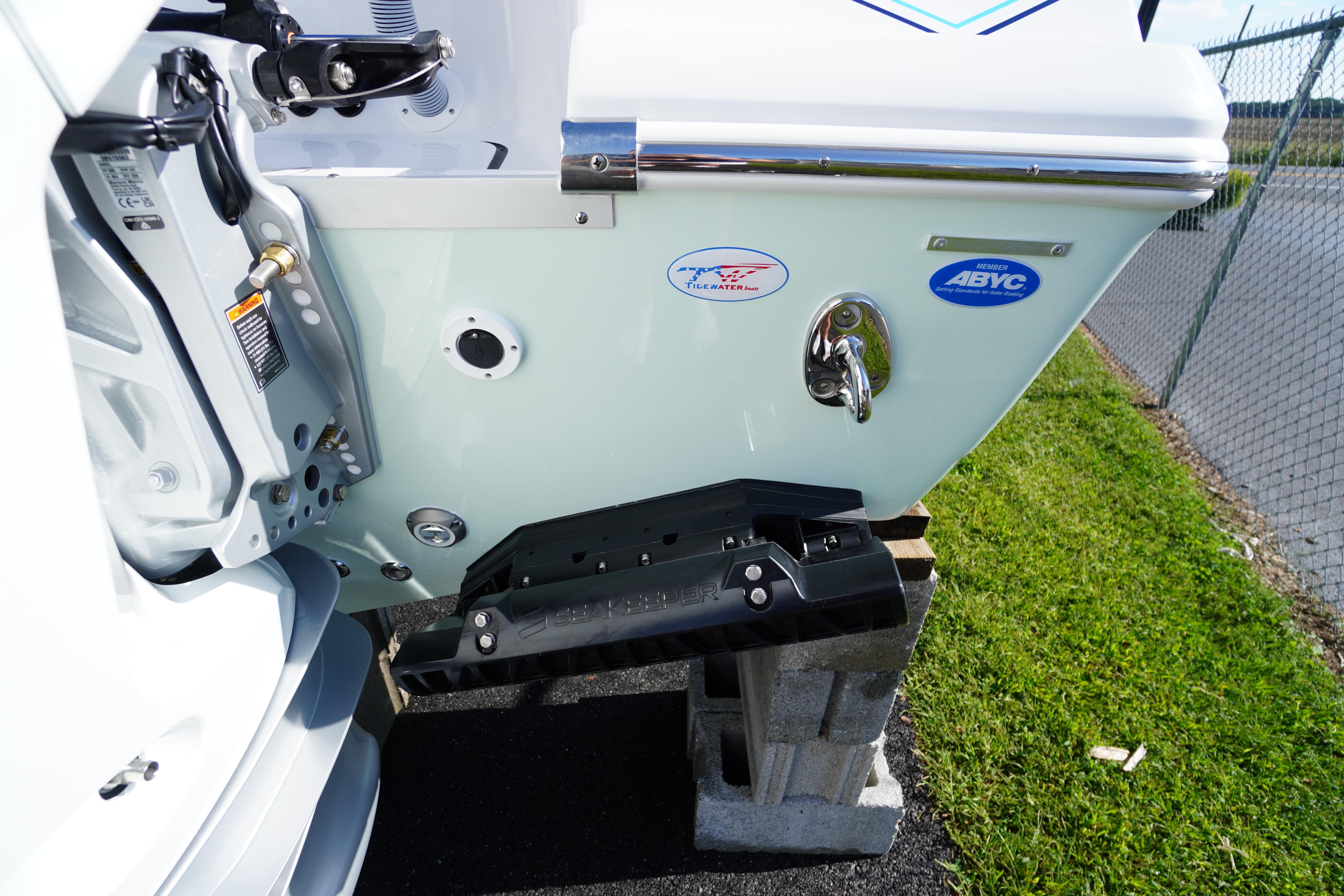 2026 Tidewater 272 LXF boat stern with trim tab and logos, displayed outdoors.