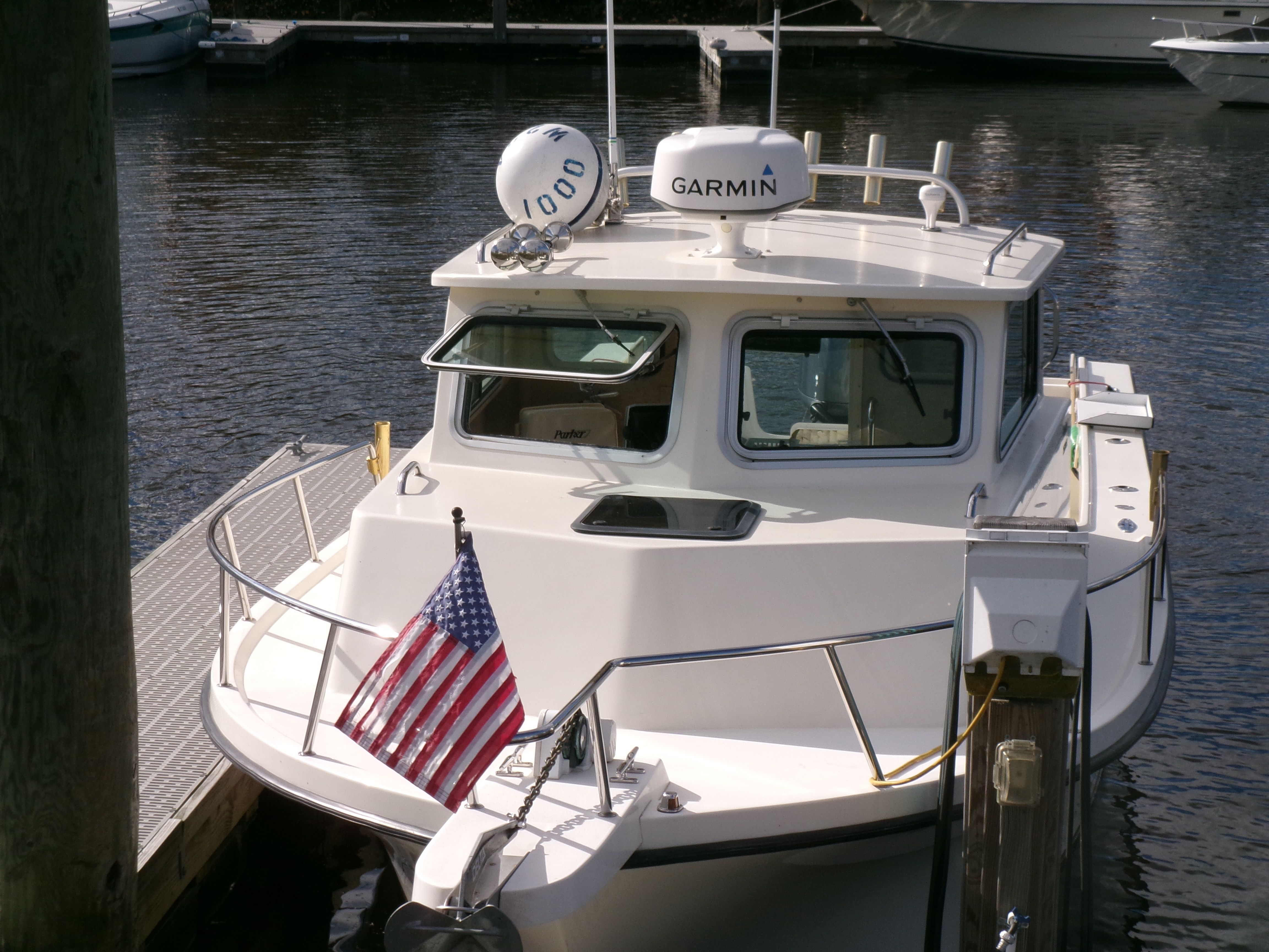 A 2007 Parker 2520 XL Sport Cabin boat docked. It features an American flag.