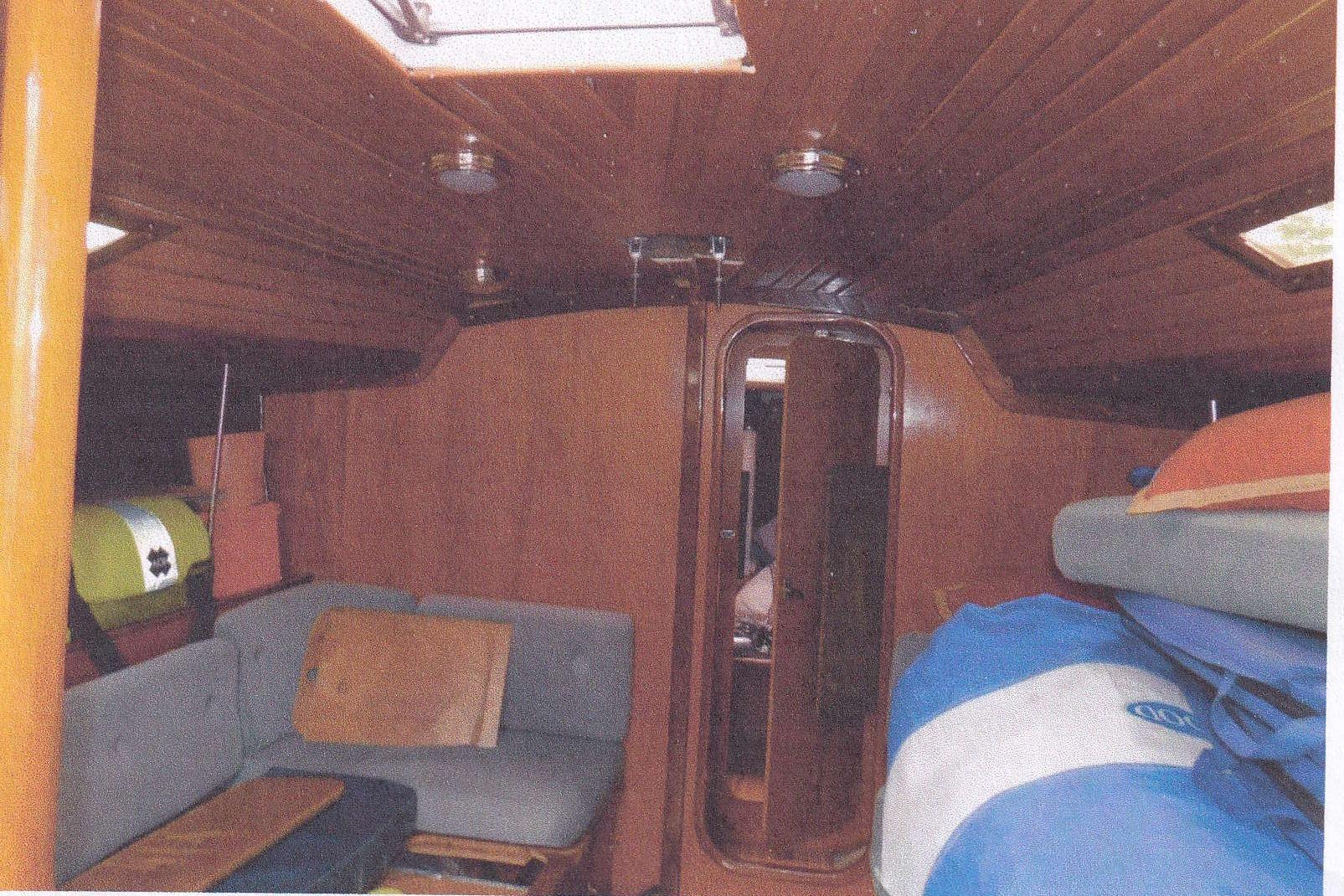Interior of 1983 Beneteau First 38.5 sailboat with wooden paneling and seating area.
