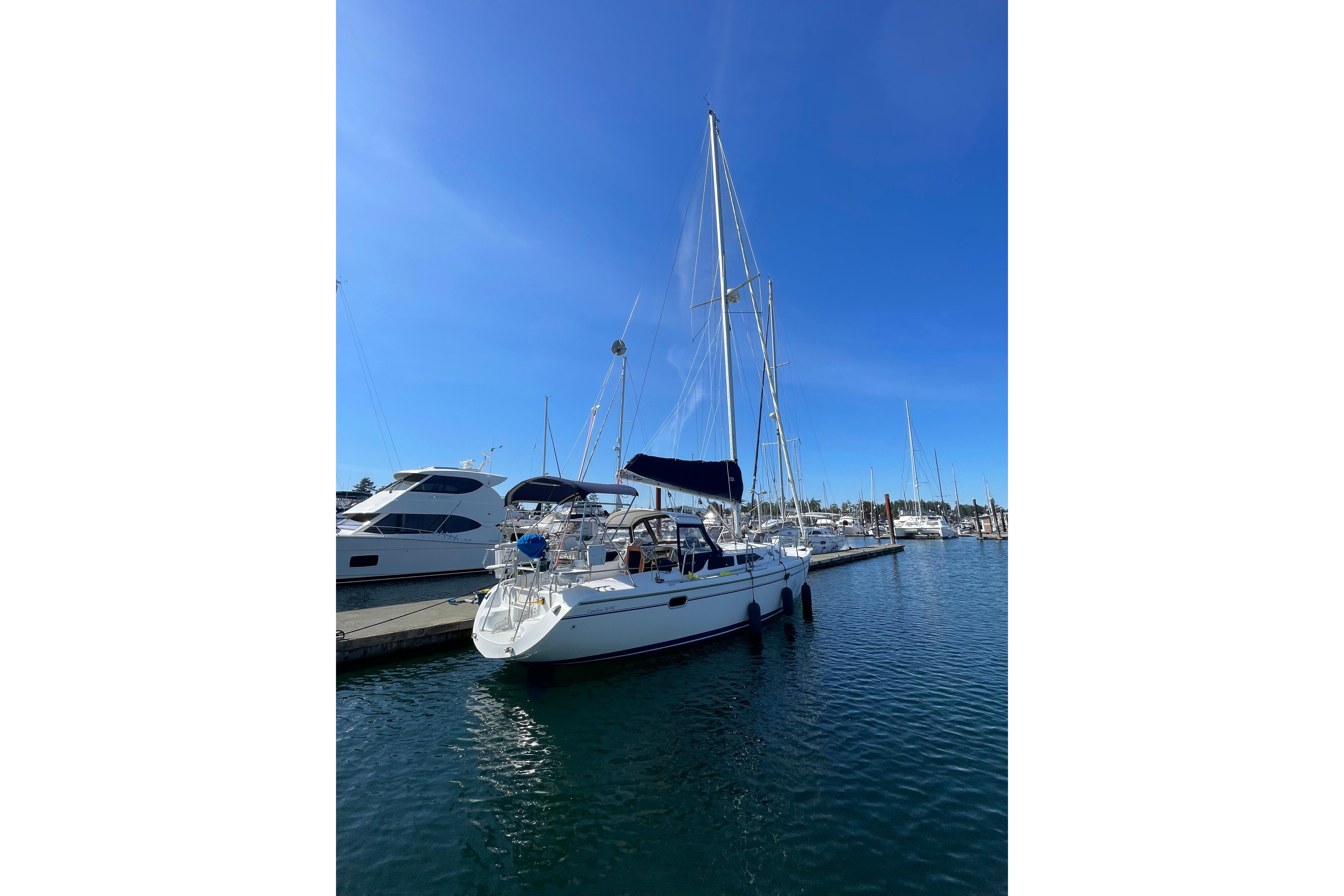 2003 Catalina 36 MkII sailboat docked in a sunny marina, clear blue sky.