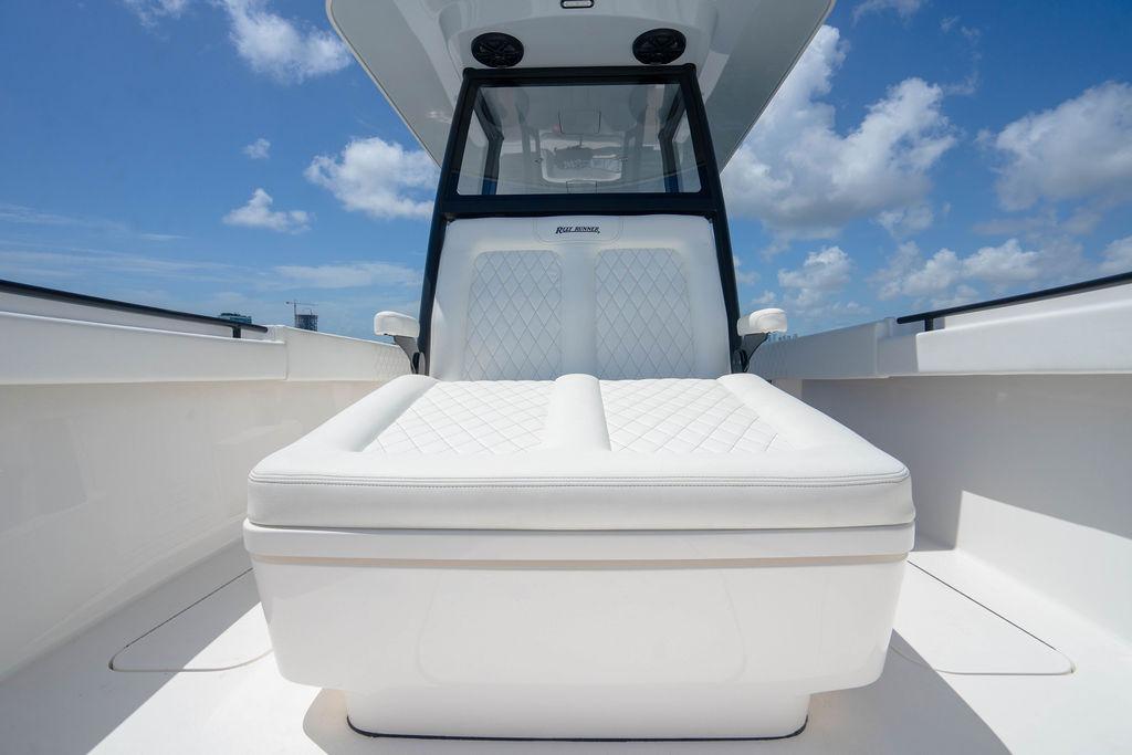 Luxurious seating on 2027 Reef Runner 340 boat under clear blue sky.
