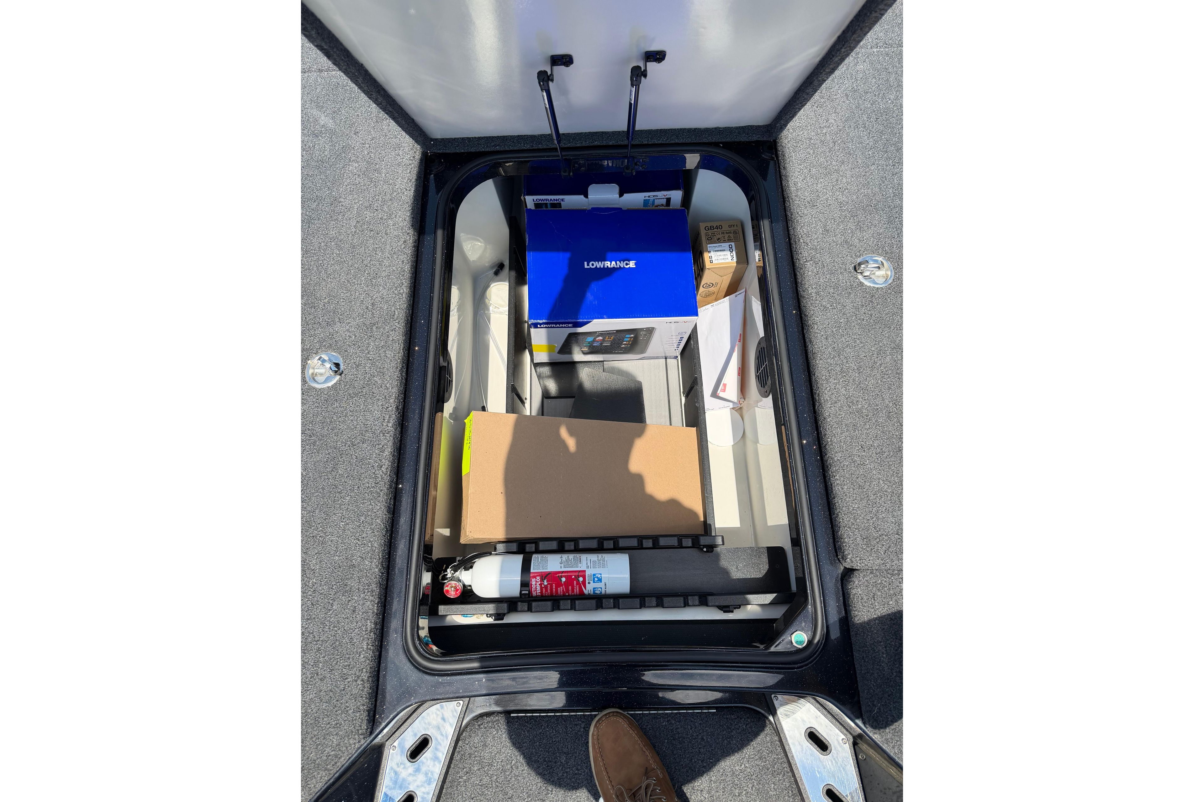 Storage compartment of 2023 Ranger Z520R boat with equipment and fire extinguisher.