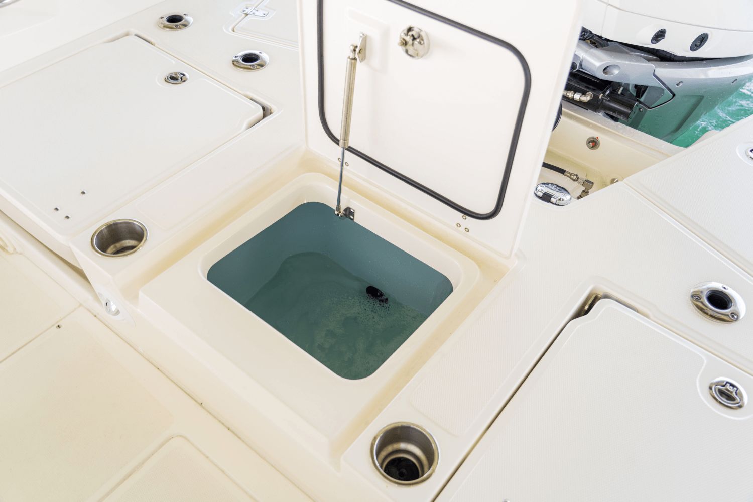 An open storage compartment on a boat with water inside.