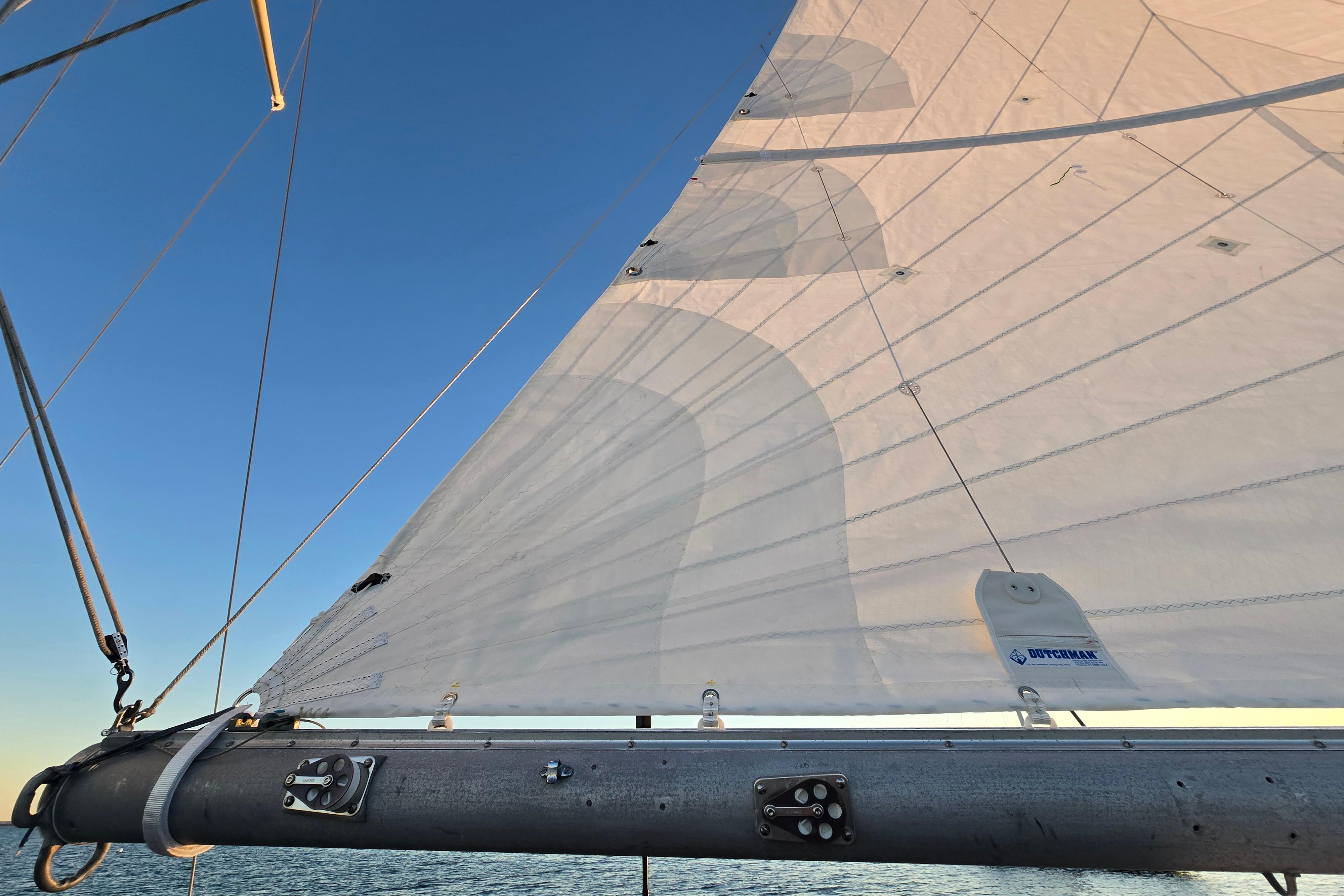 Sail of a 1970 Hinckley Bermuda 40 yacht against a clear blue sky.