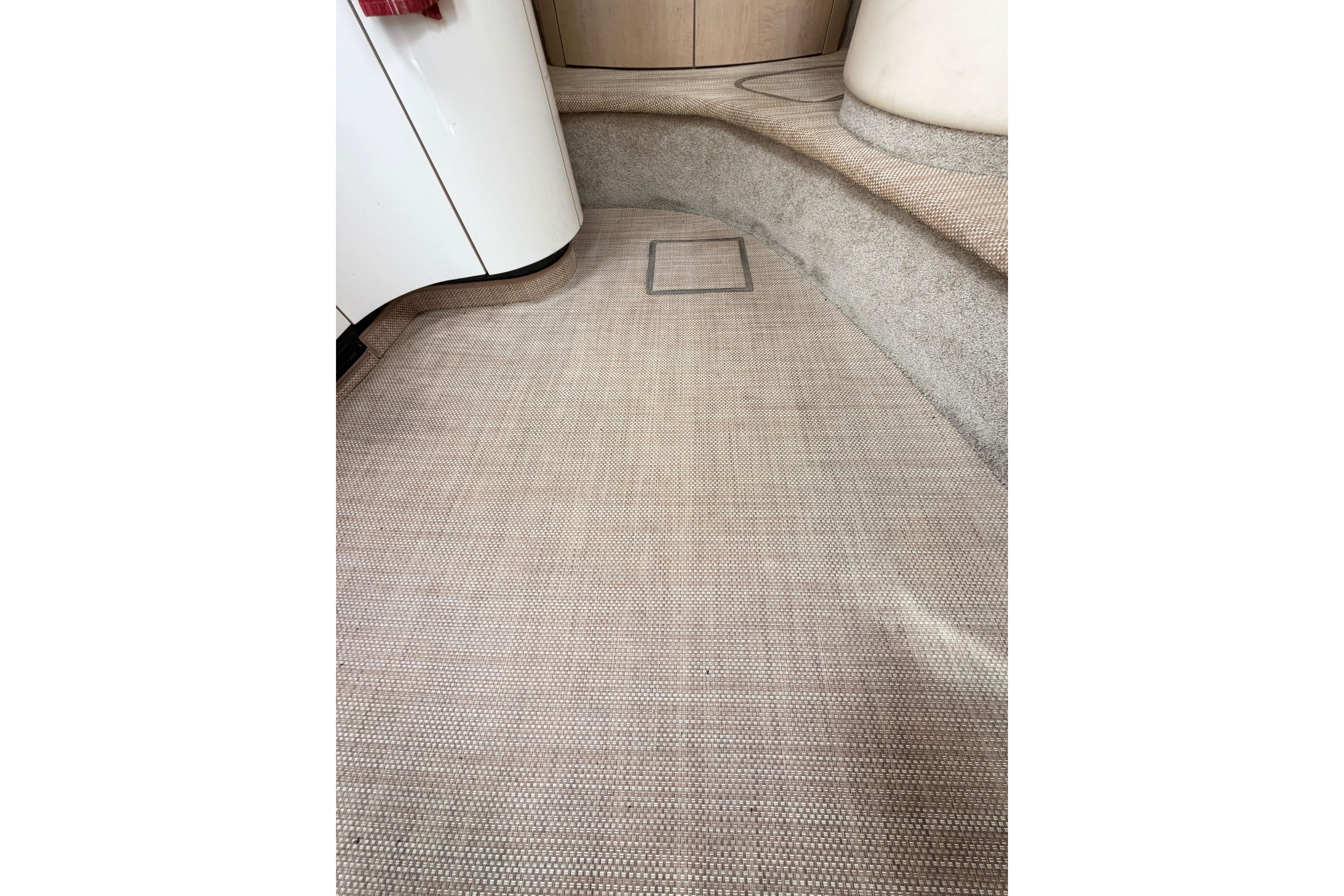 Interior flooring of a 2000 Maxum 3700 SCR boat, featuring beige carpet and curved design.