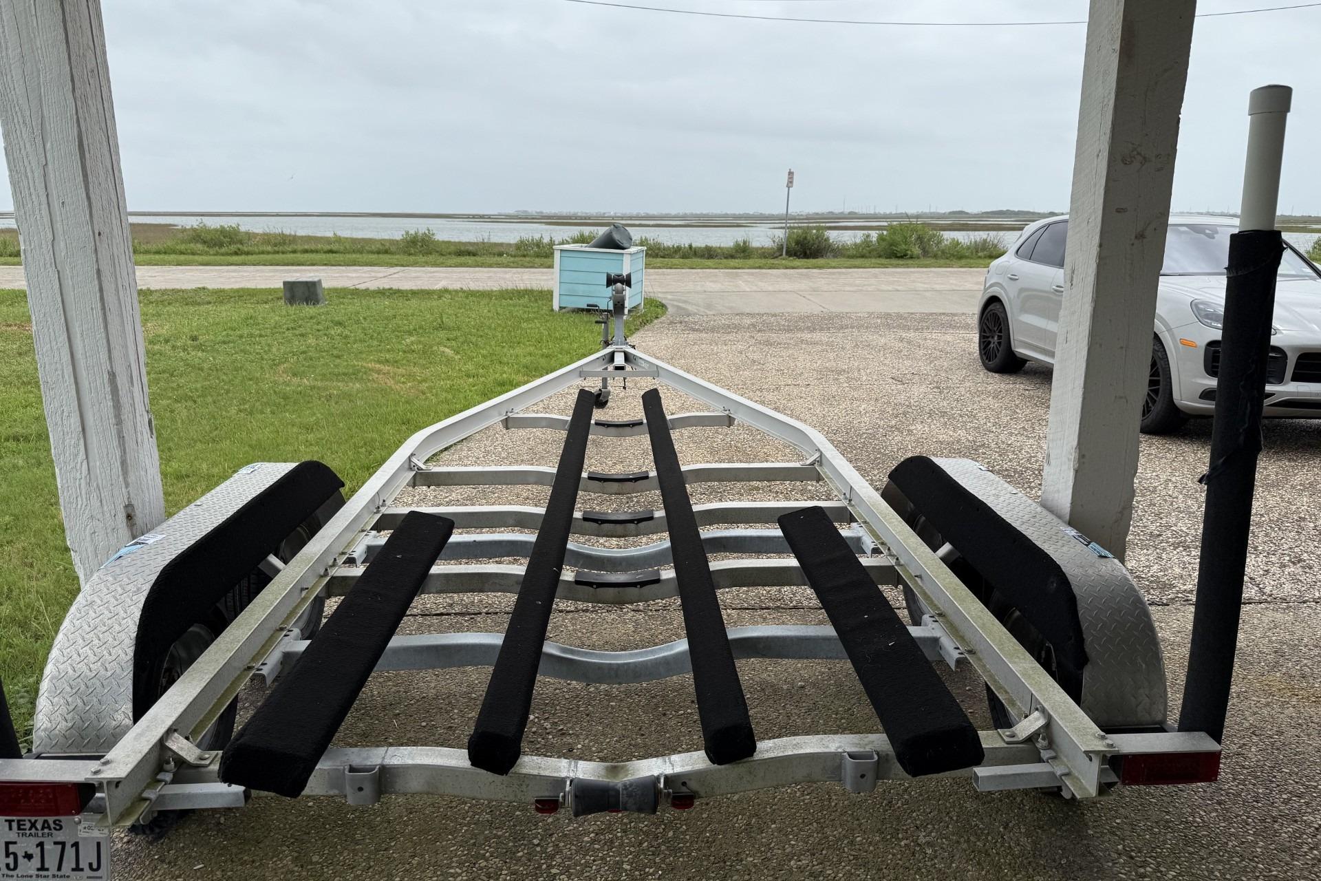 Boat trailer for 2017 Blue Wave 2200 PureBay, parked near waterfront.